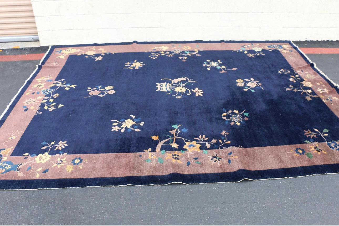 Wunderschöner großer Vintage-Teppich im Art-Déco-Stil aus China um 1930. Dieser erstaunliche Teppich zeigt ein weitläufiges, mit Blumen verziertes Feld. Es hat eine schöne tiefe Indigofarbe. Dieser Teppich ist aus pflanzlich gefärbter Wolle