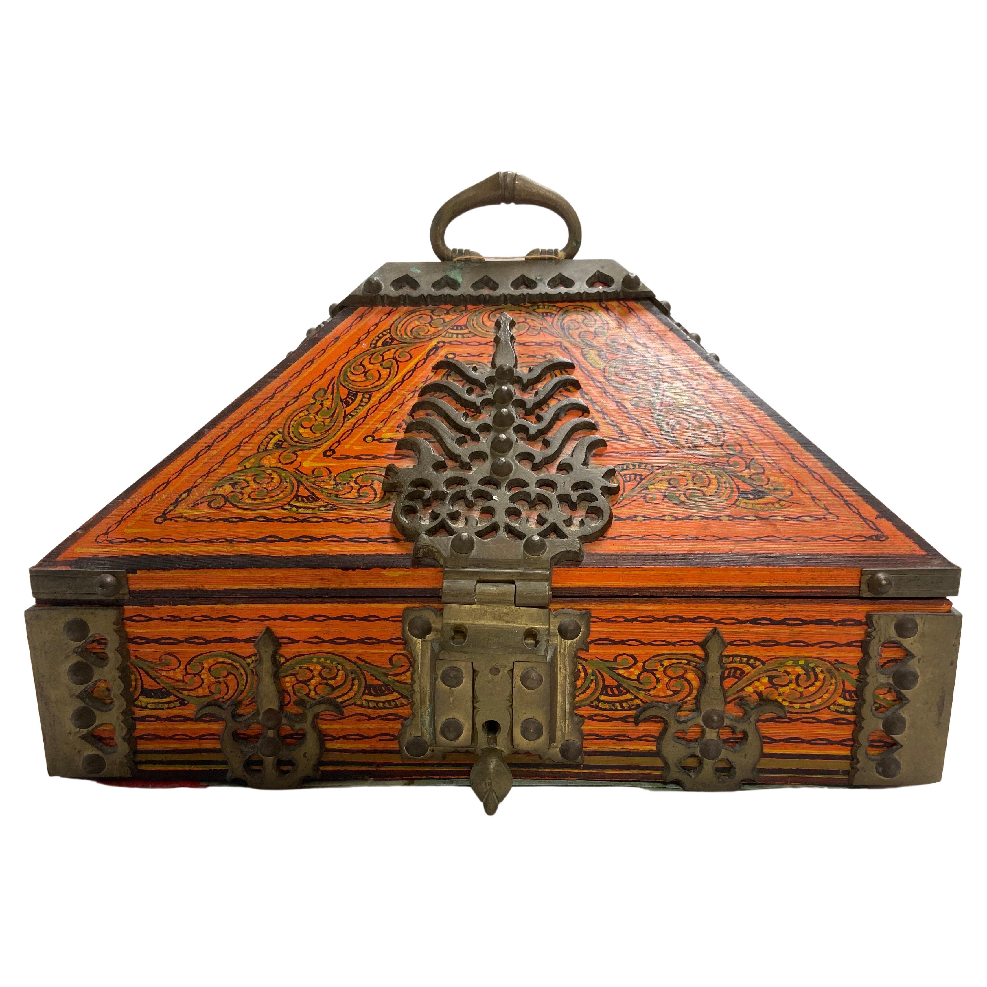 Eine alte indische Mitgiftschatulle in orangefarbener Farbe mit schönen handgemalten Details und Verzierungen, gesichert mit verzierten und verschnörkelten Messingscharnieren, Griff und Verschluss. Die Schachtel hat auch ein Innenfach mit