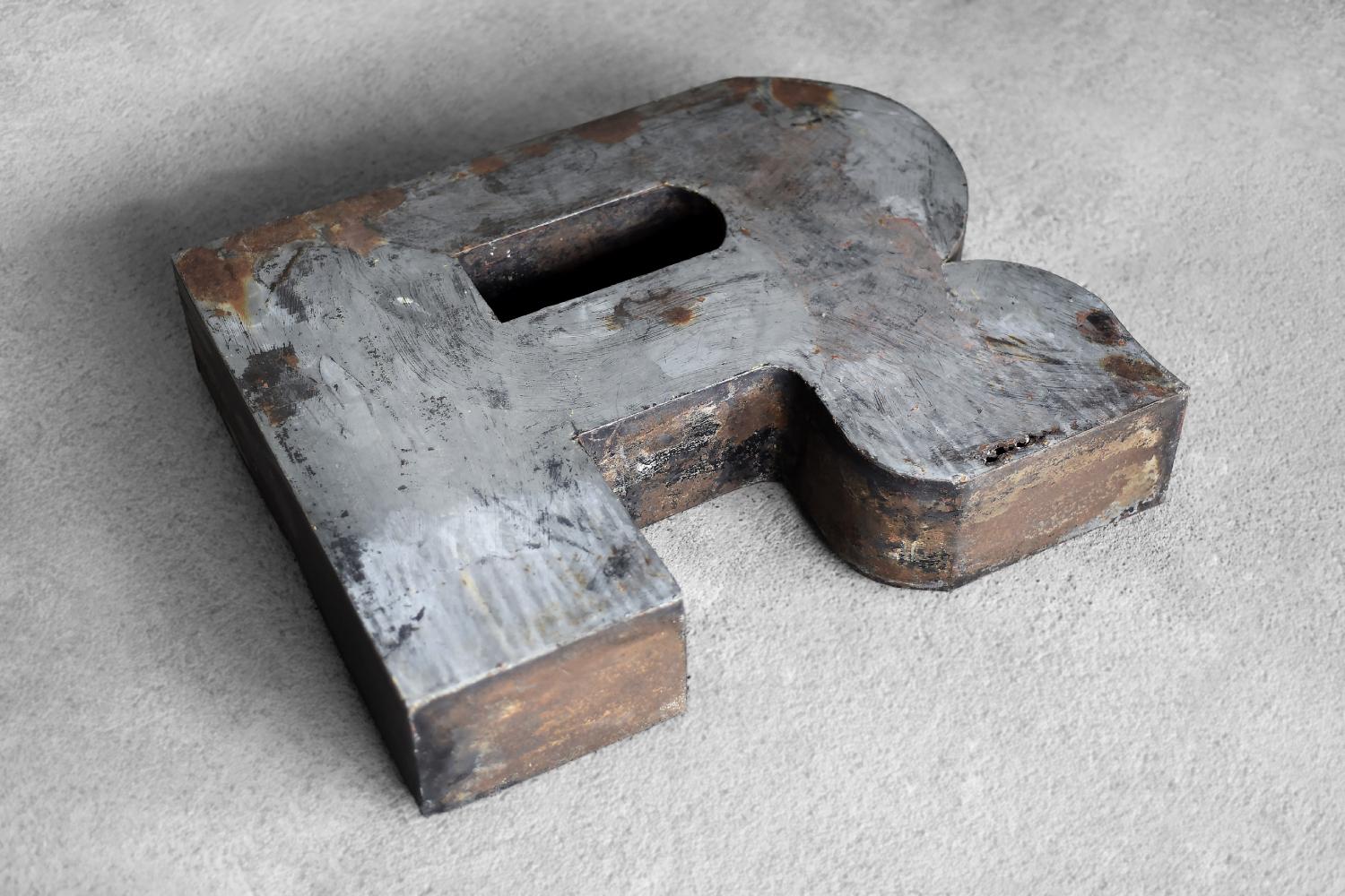 This large, spatial letter R was produced in Poland during the 1950s. It was made of metal. It is an original element of the sign of a former restaurant in Poland, which was exposed outside, hence traces of natural patina. The three-dimensional