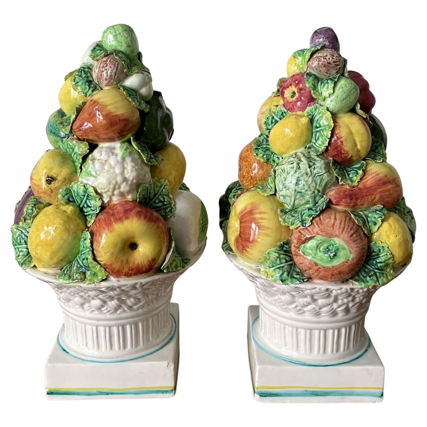 Pair of Majolica glazed ceramic fruit & vegetable topiaries. Made in Italy, featuring a mix of fruits, vegetables and greens towering over a woven basket base.



