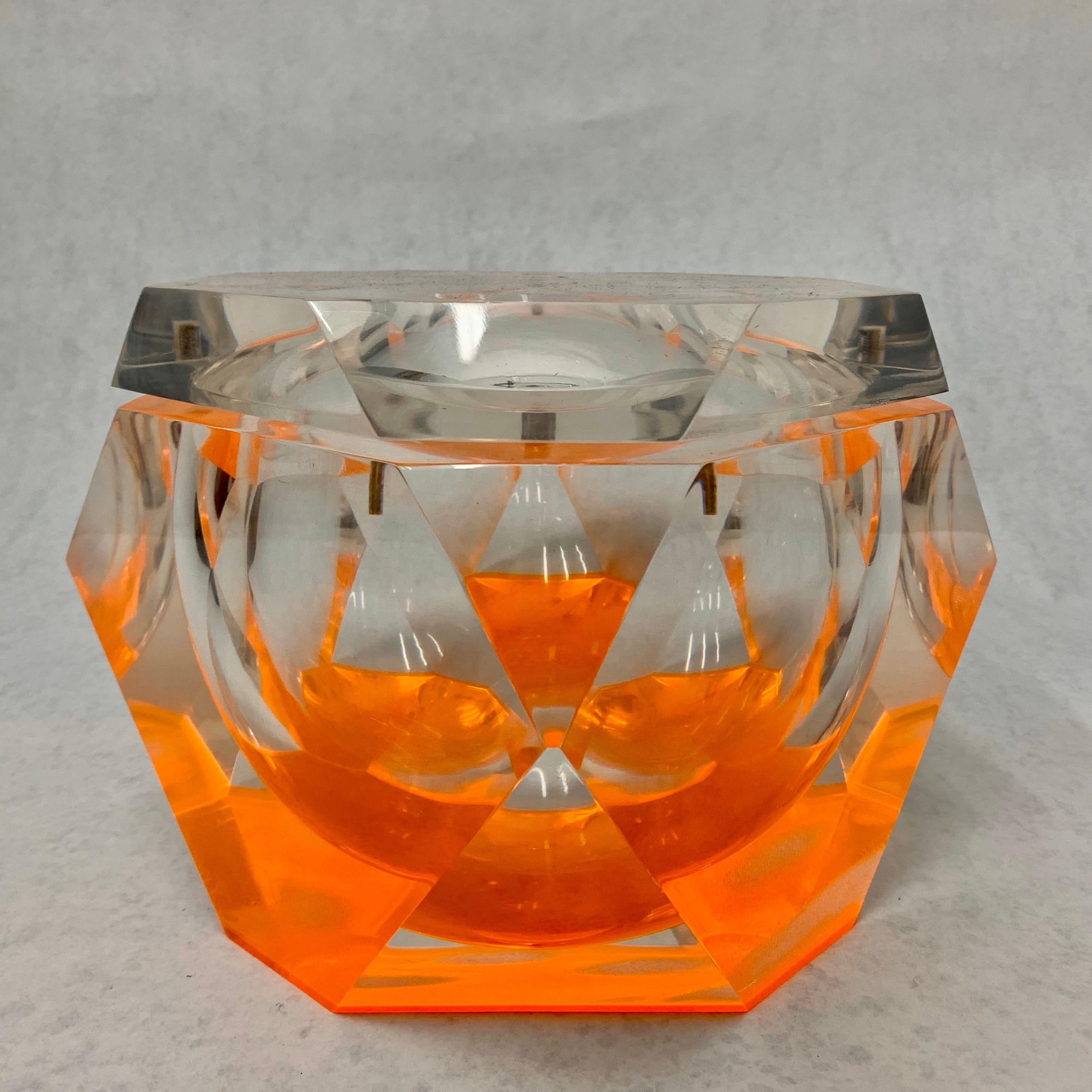 This oversized geometrically designed Italian ice bucket by Albrizzi with swing top is unique because of its orange hues which are enhanced by the sharp facets of the Lucite design. The jewelry style facets make this large chunky piece a must have!
