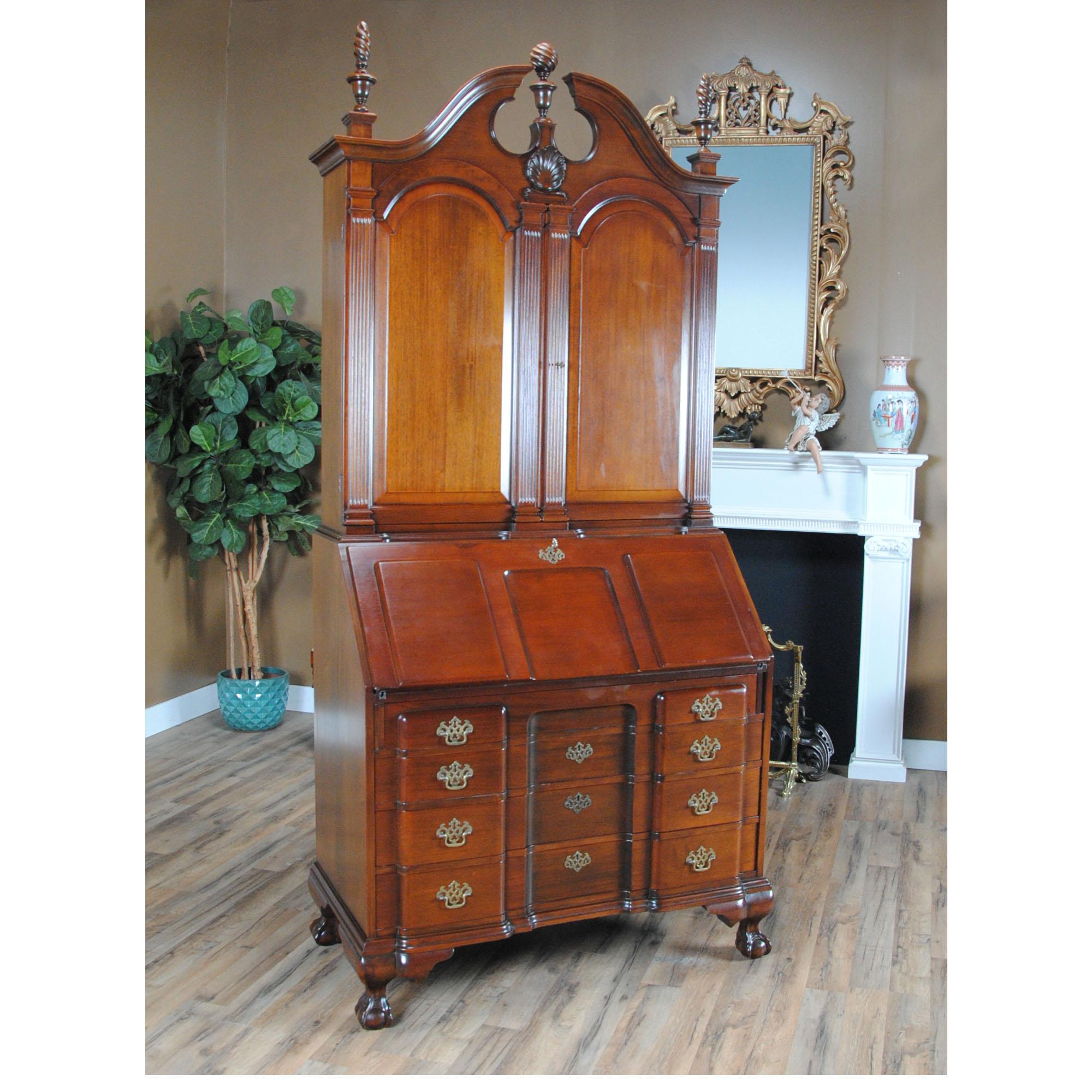 A Vintage large mahogany secretary desk. This desk is impressive in both it’s design and scale. Made of beautifully grained solid mahogany, the bookcase features removable finials as well as adjustable shelves in the interior of the cabinet. The top