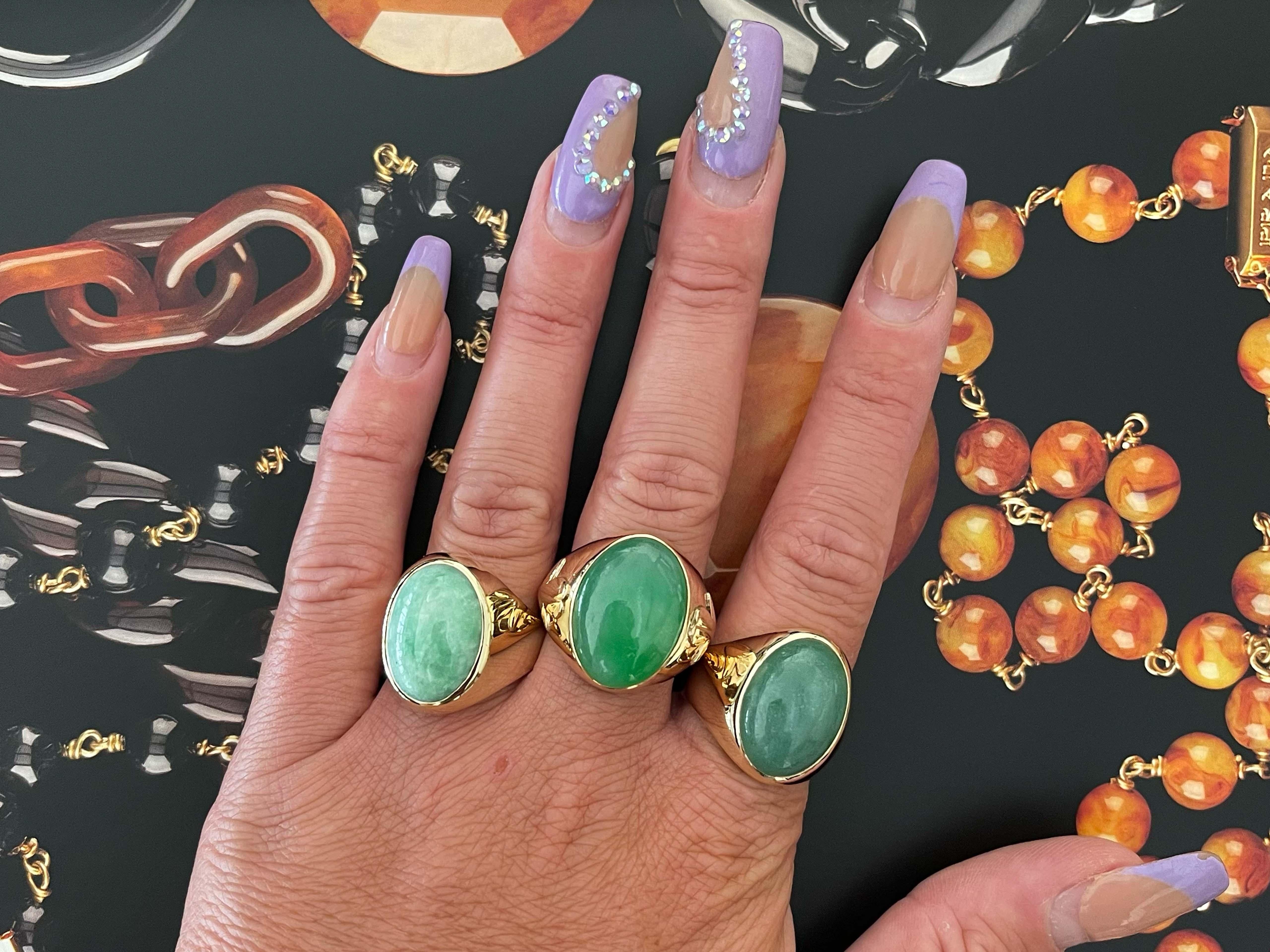 Magnificent vintage oval cabochon pale mottled green jade ring, in 14k yellow gold. The Jade is bezel set and measures approximately 17.78 mm x 12.71 mm x 5.70 mm. The ring has a tapered shank with a high polish finish. The ring is size 8.5 and can