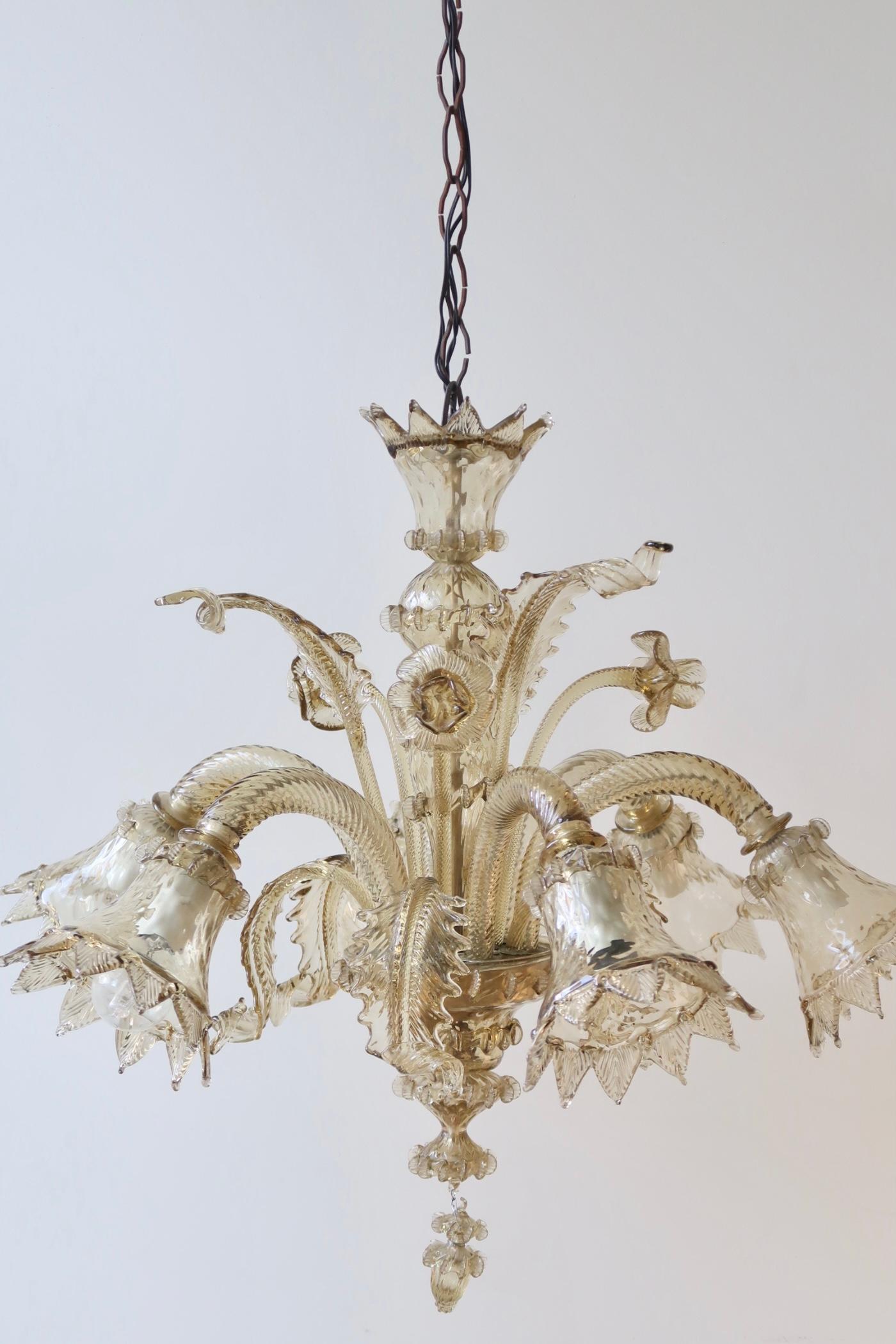 Beautiful vintage Murano chandelier.

The chandelier is made of hand blown golden glass and consists of 6 arms, each with its own light source. Incredibly detailed with mouth blown flowers and leaves. The techniques used are most often seen at