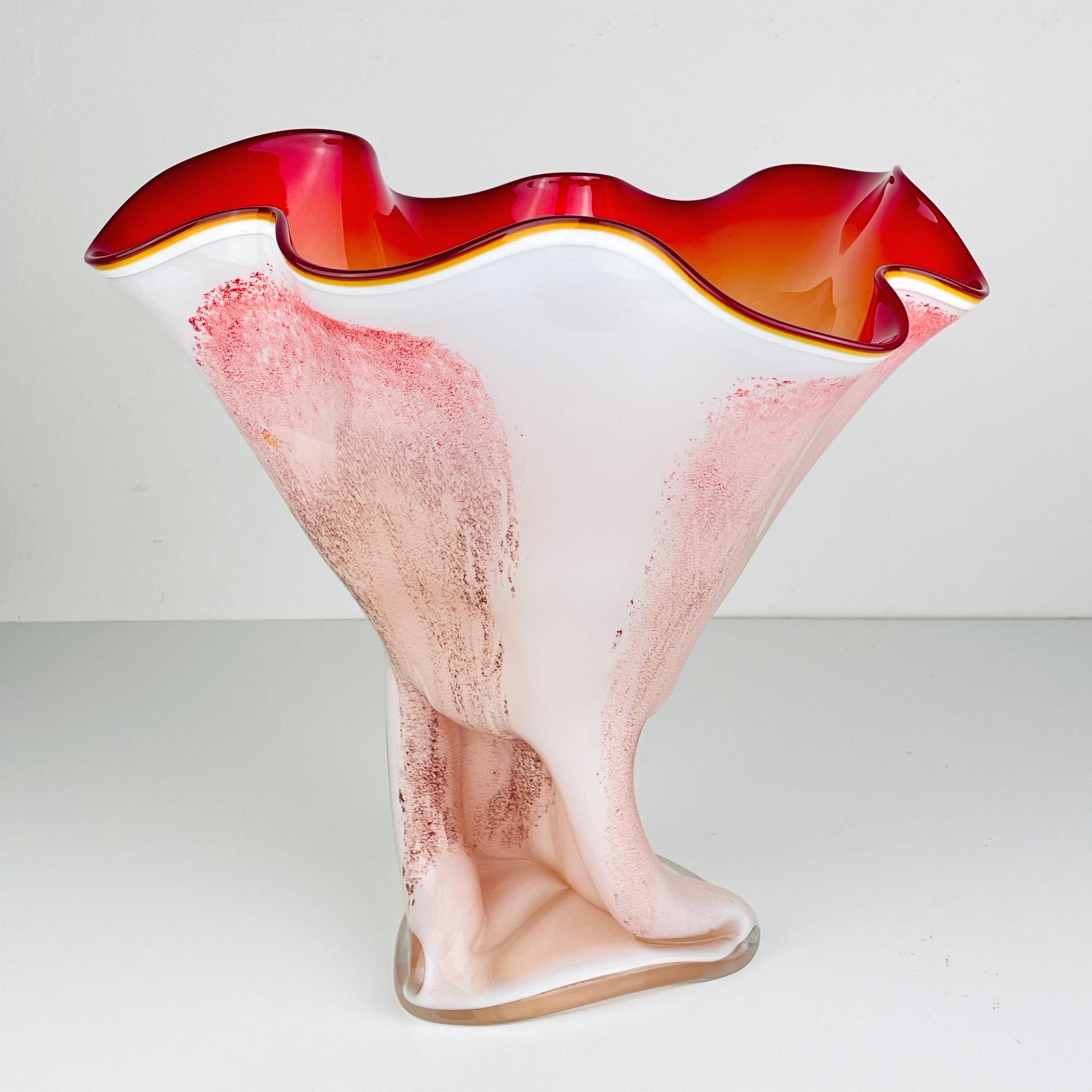 Diese faszinierende Vase aus Murano-Glas aus der Mitte des Jahrhunderts, eine prächtige Kreation aus dem Italien der 1970er Jahre, ist ein Ausdruck italienischer Kunstfertigkeit. Das ursprüngliche Label ist erhalten geblieben. Das schlichte und