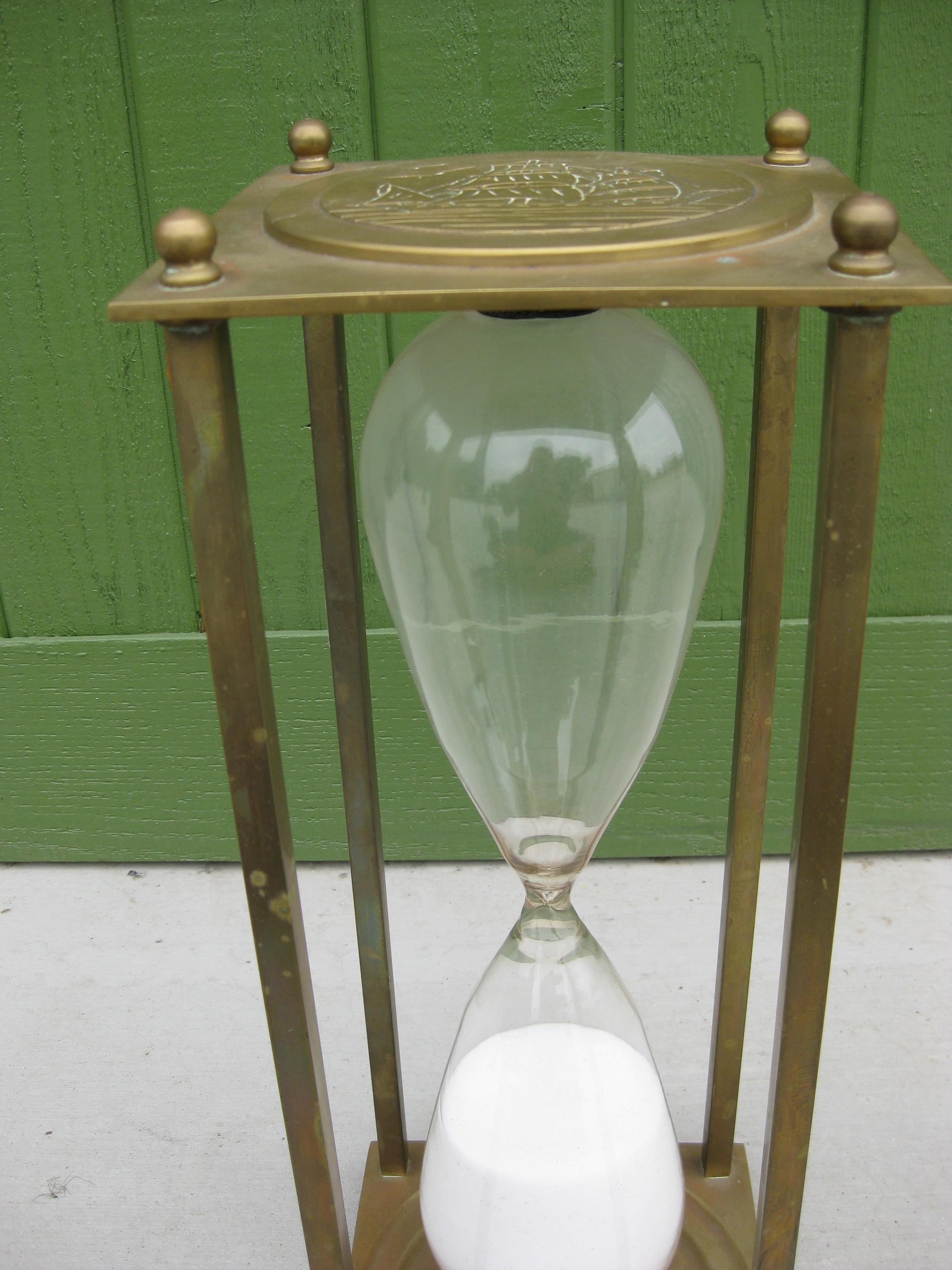 Very unique large maritime/nautical brass and glass hourglass. Wonderful dorm and design. Brass has a wonderful patina and can be polished if desired. Has a ship design engraved on both ends. The sand timer runs about 4 hours. In very nice original