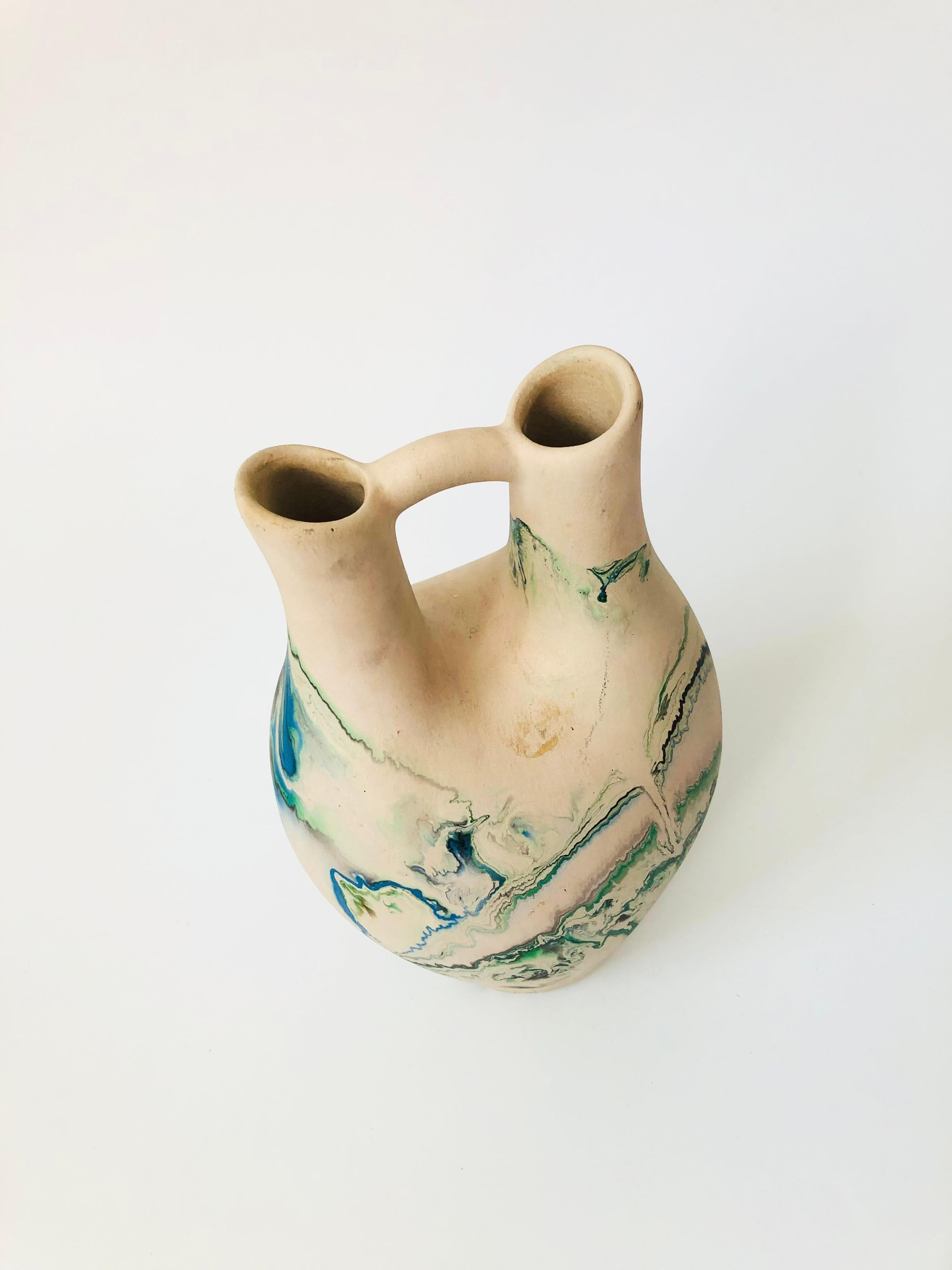 A large vintage Nemadji Pottery wedding vase with a beautiful organic pattern of green and blue swirls on a light off-white background. Beautiful matte finish.