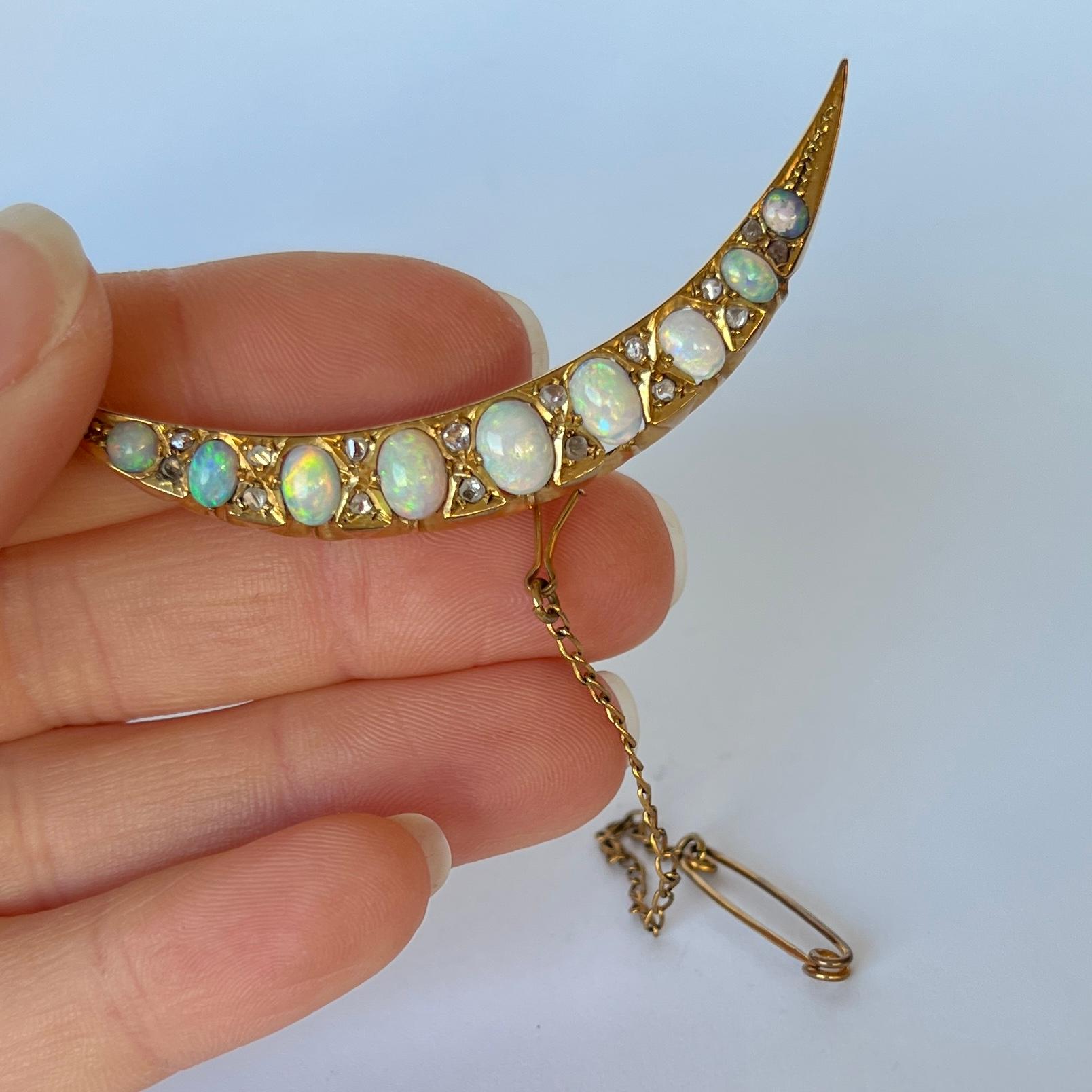This exquisite brooch is set with 9 glowing opals. They have flashes of fiery red and so any other wonderful colours. In-between each opal there are a pair of sparking diamonds. Modelled in 15ct gold. 

Length: 58mm

Weight: 6.1g