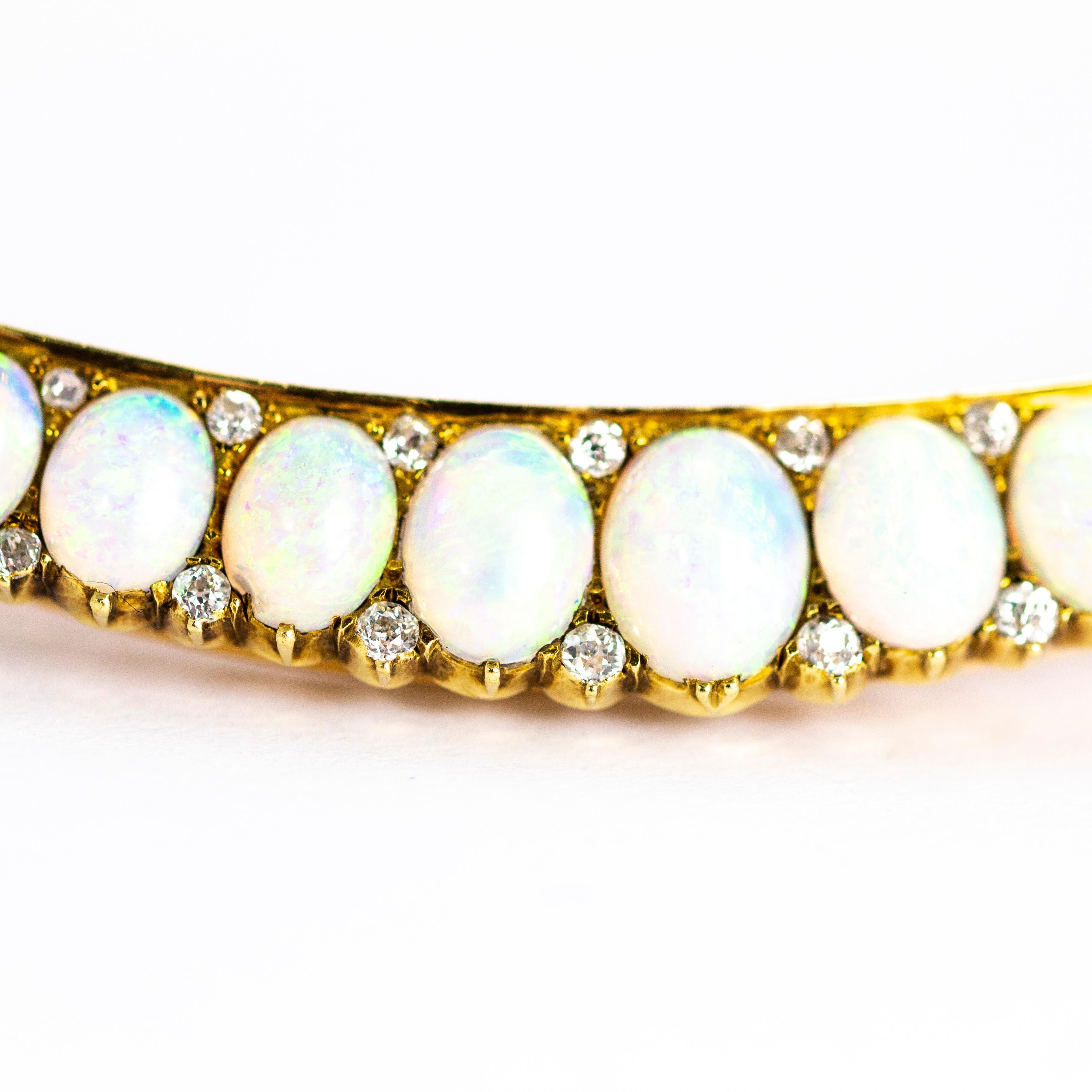 An exquisite large vintage crescent brooch fully set with opals and diamonds. The 23 spectacular graduated opal cabochons with fantastic height, each of these stones is from the same source and so share the same exceptional colour throughout. The