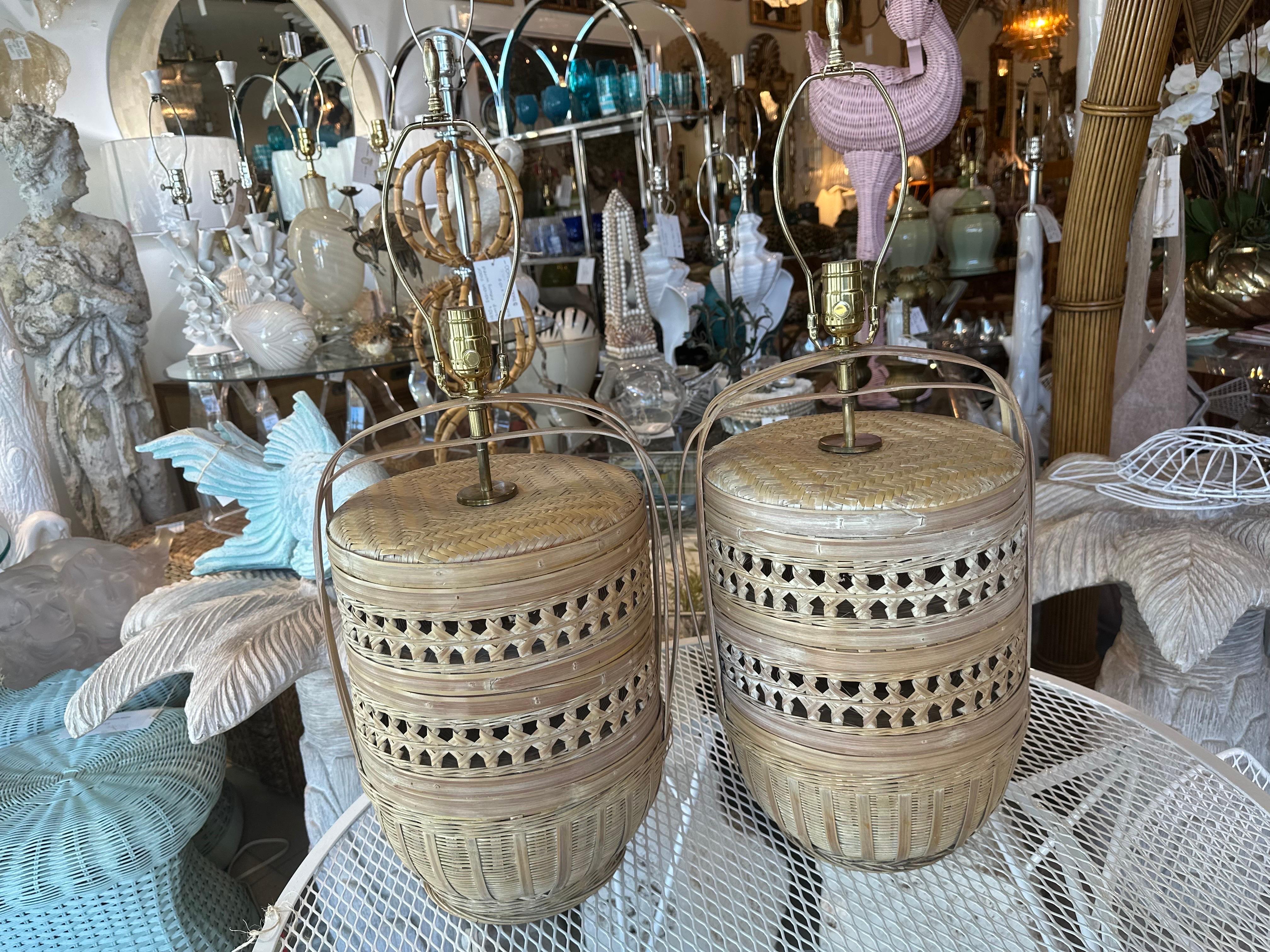 Vintage pair of woven rattan basket table lamps. These have been newly wired, clear cords, 3 way brass sockets, all new brass hardware. Dimensions: 28 H (to top of finial) x 20 H (to top of sockets) x 12 D. 