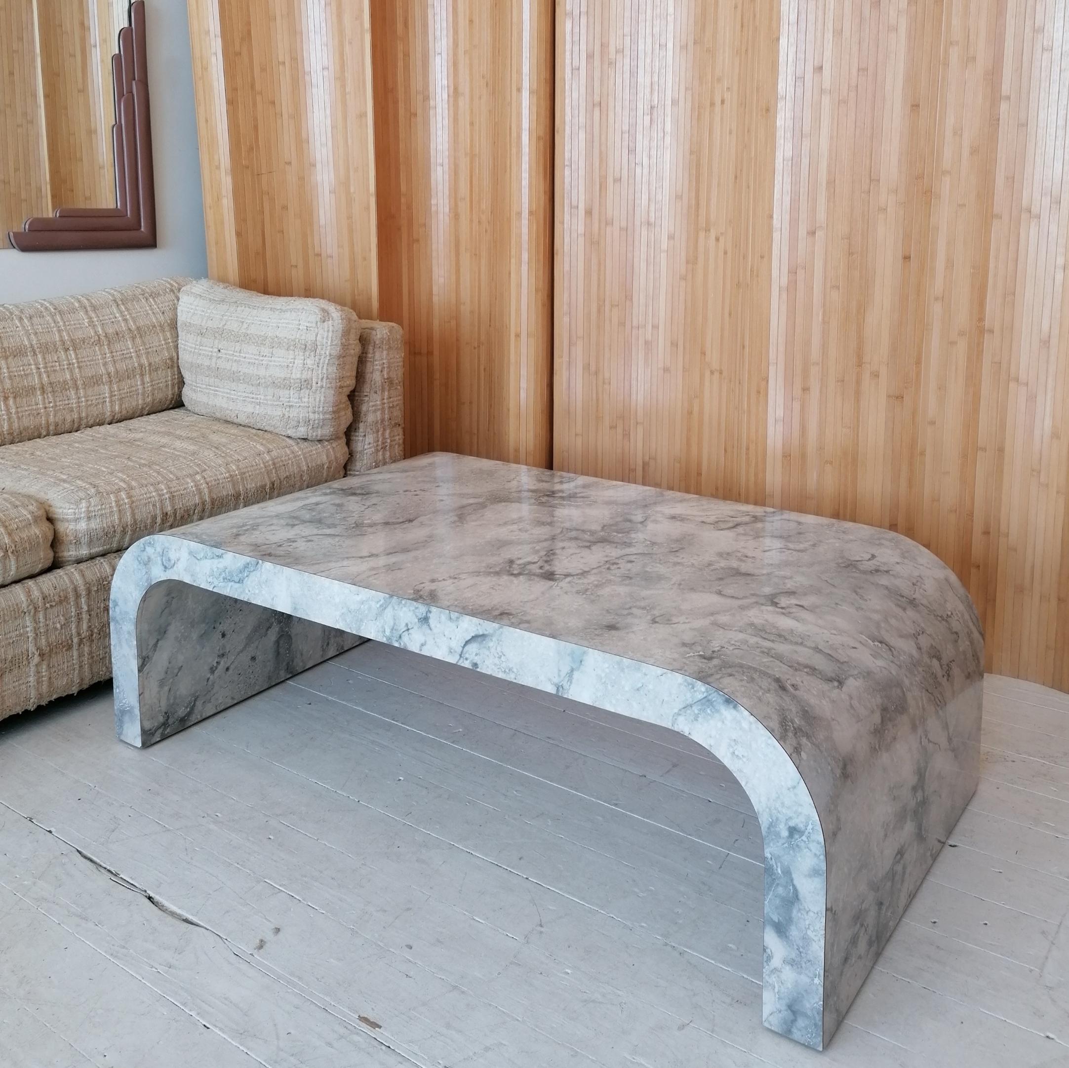 This large post-modern American 'waterfall' coffee / cocktail table epitomises the super-desirable 1980s look that's coming into its own.
This example is entirely covered in its original faux carrera marble laminate (which is basically an American