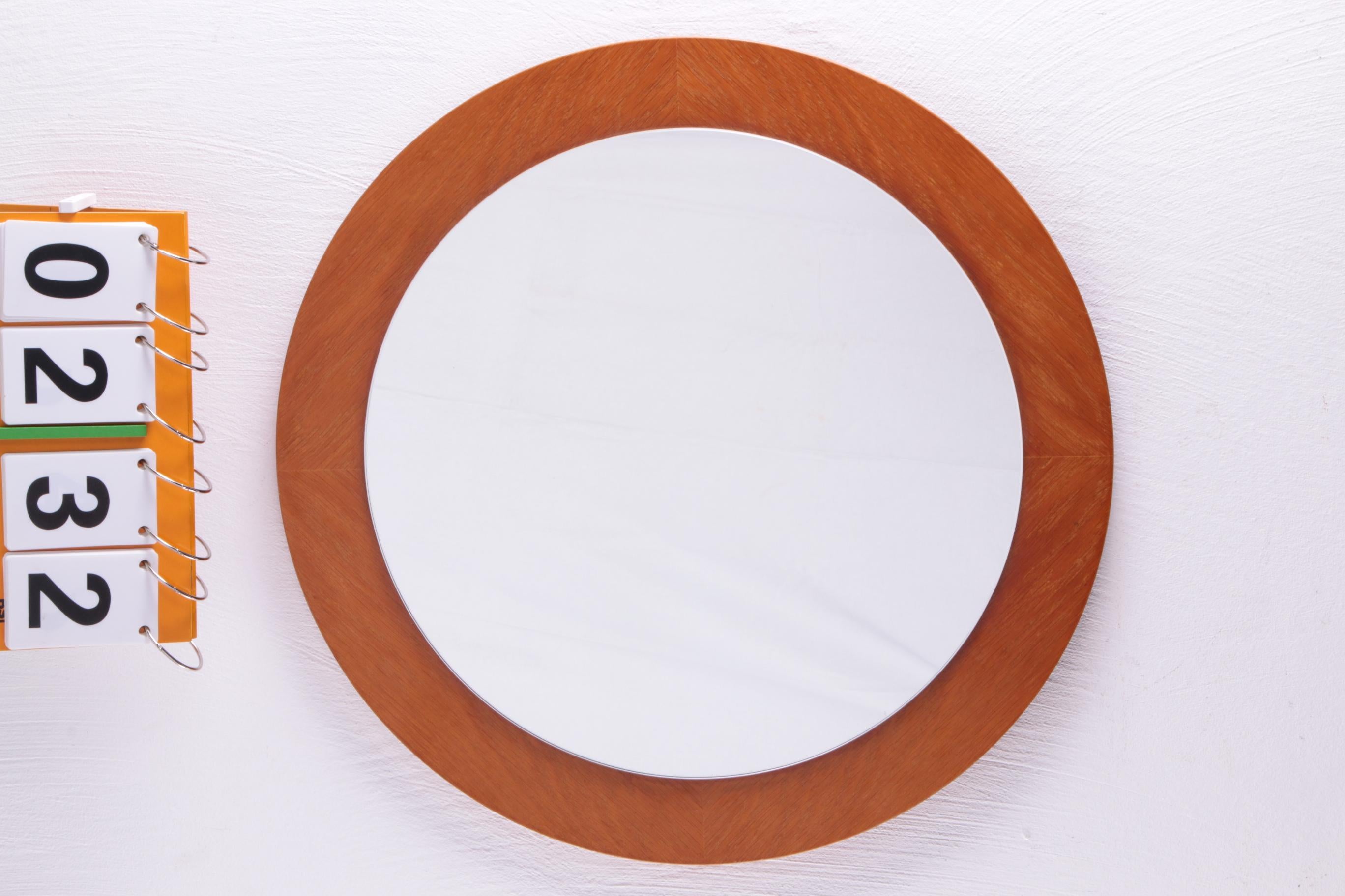 A beautiful large round mirror made in Denmark around the 60s. Whether you put it up in the bathroom or bedroom, this mirror will add a subtle warm touch to your interior.

The mirror is mounted on a round light wooden surface. This gives the mirror