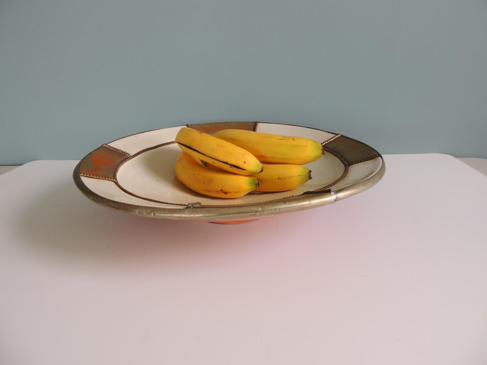 Vintage large round Moroccan terracotta serving bowl with tin metal adornments.
rustic centerpiece.
Small hold in the back to hang it on the wall.
Size: 16