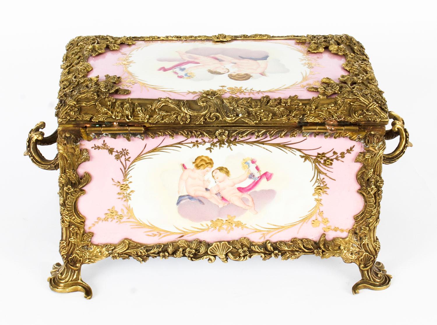 This is a beautiful large Vintage Russian Revival porcelain and ormolu mounted jewellery casket in rose pink, dating from the last quarter of the 20th century.

This highly decorative piece is hand painted with cherubs and musical instruments, has a