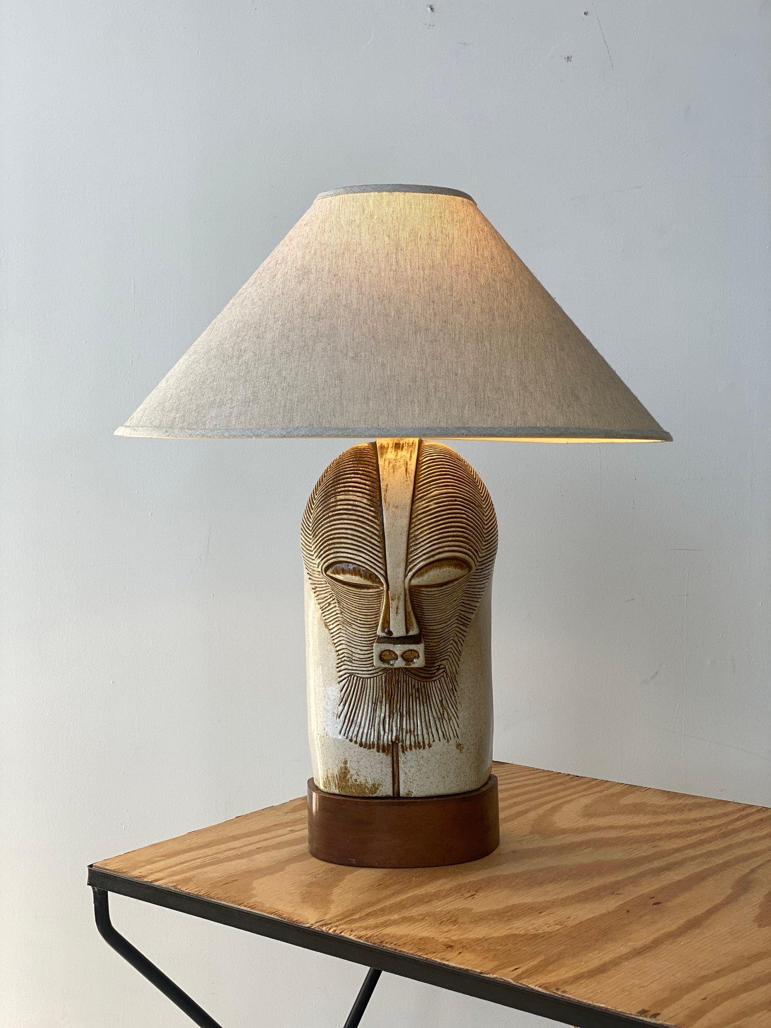Vintage Large Scale Ceramic Kifwebe-Inspired Mask Lamp on Mahogany Base, Circa 1950s. A gorgeous interpretation of a Congolese Kifwebe mask rendered in off-white stoneware with incised surface detailing in shades of tan and brown. Mounted on a solid