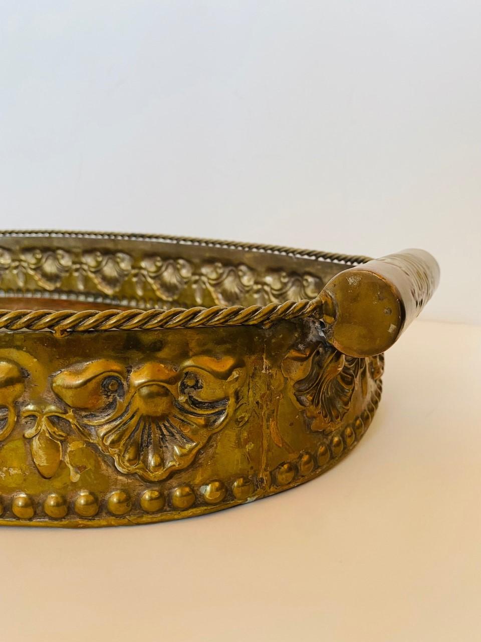 A large handled serving tray composed of copper, brass, nickel and bronze beautifully combined in a unique design. This piece has aging that translates into making this piece look regally eclectic. A simple but ornate design predominates in the