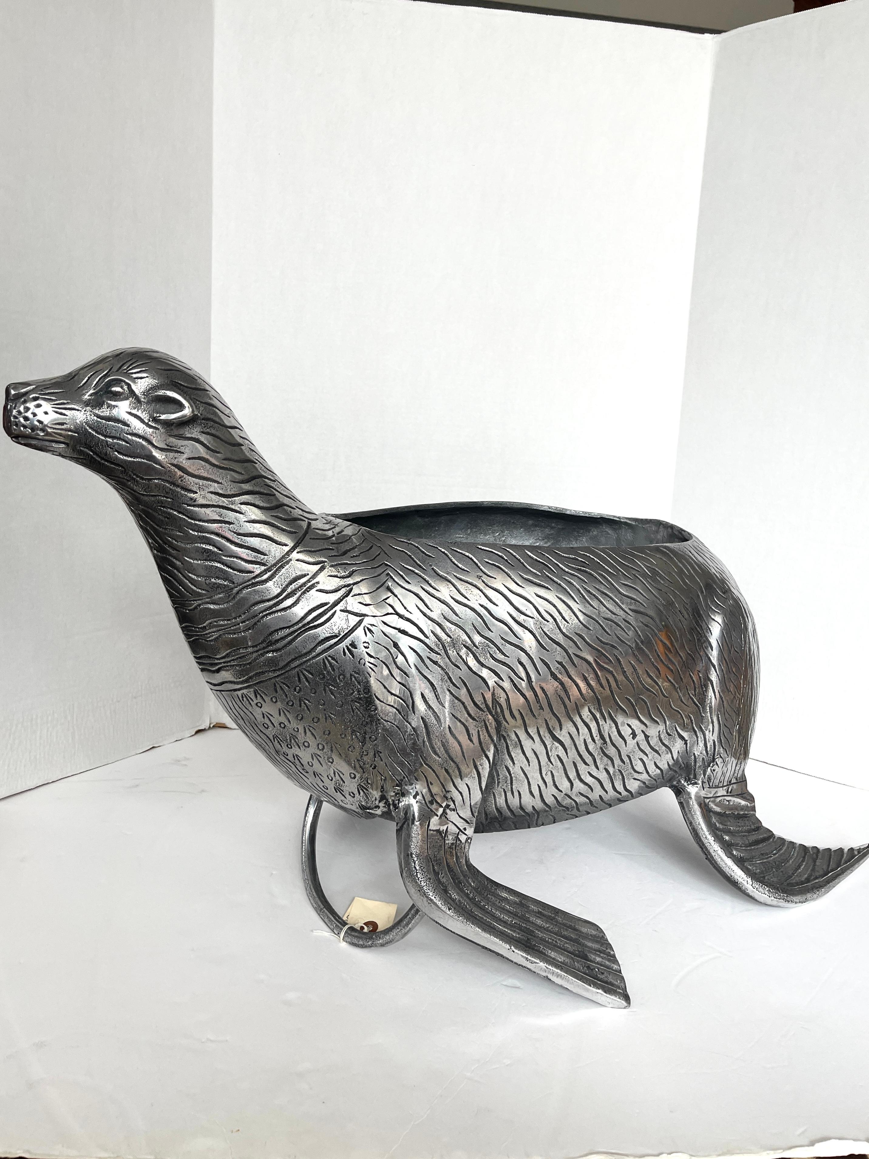 Appena arrivato in questo Vintage molto grande Silver tone Cast Stainless Steel Seal Wine Cooler
Questa guarnizione può contenere tre sacchi di ghiaccio e almeno sei bottiglie di vino o champagne.
Questa guarnizione è molto pesante perché, a quanto