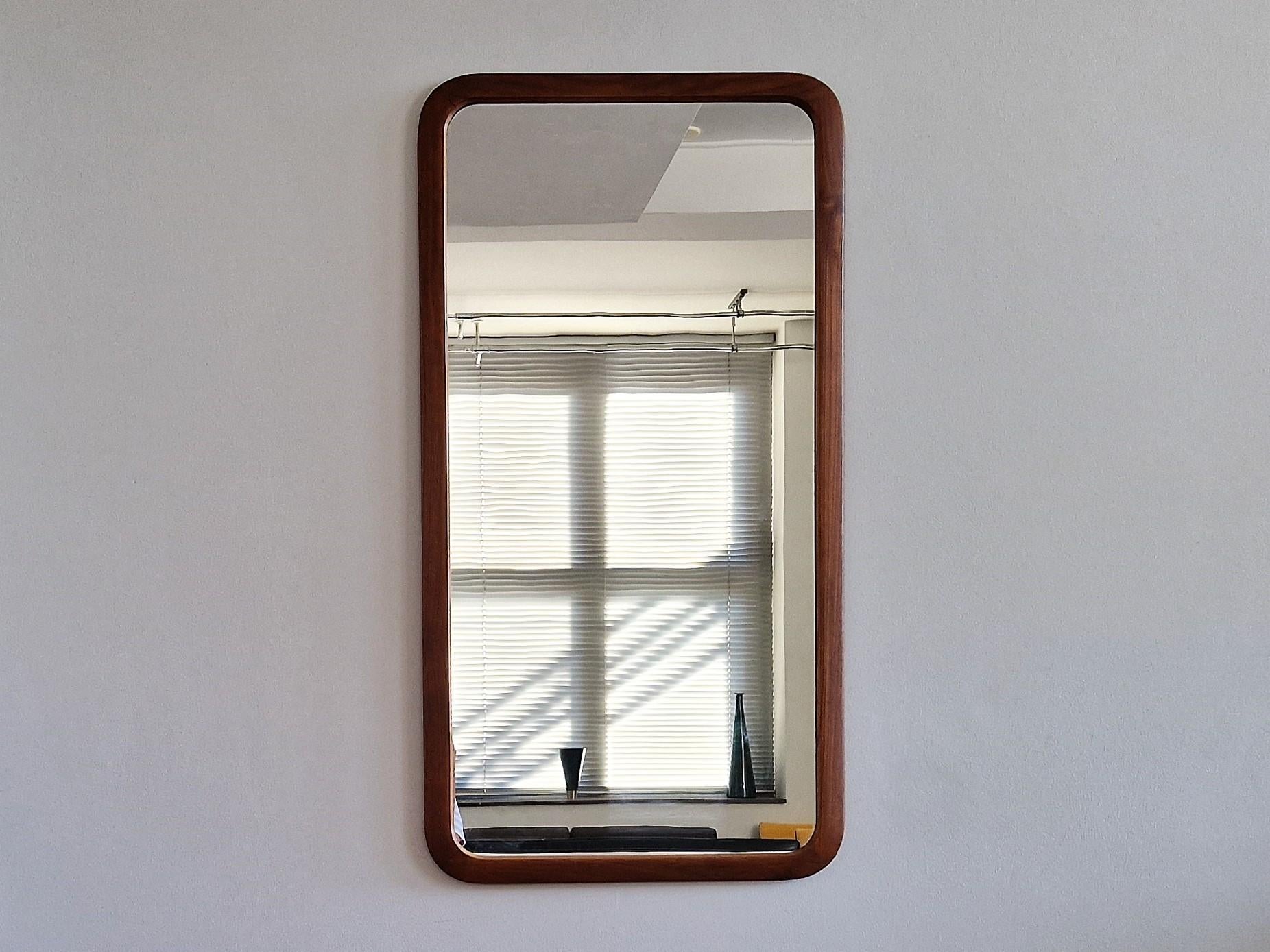 This very nice Danish mirror was likely to be made in the 1960's. It has a beautiful rectangle shape in a teak frame that was recently oiled. Both the frame and mirror part are in a good condition with signs of age and use, mainly some discoloration