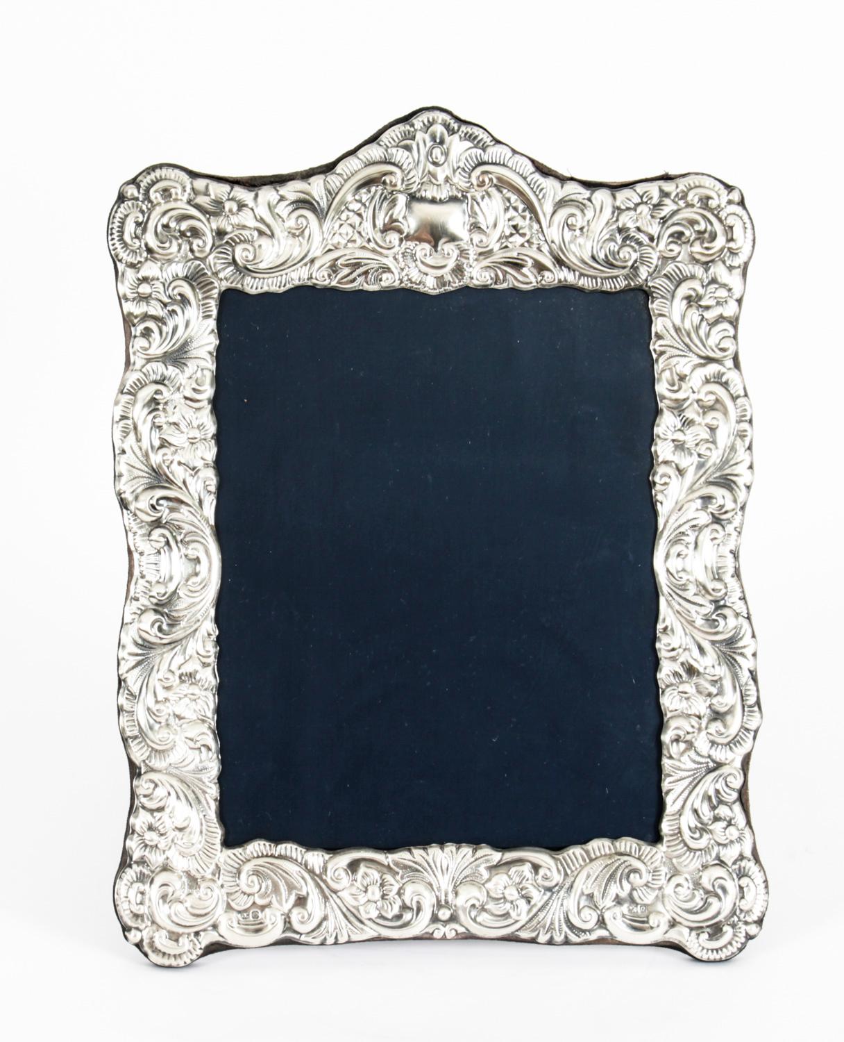 A large truly superb elegant large sterling silver photo frame by Carrs of Sheffield with hall marks for 1990.

The vertical frame has a black velvet back with rectangular border decorated with garlands and swags and features an easel back. 

An