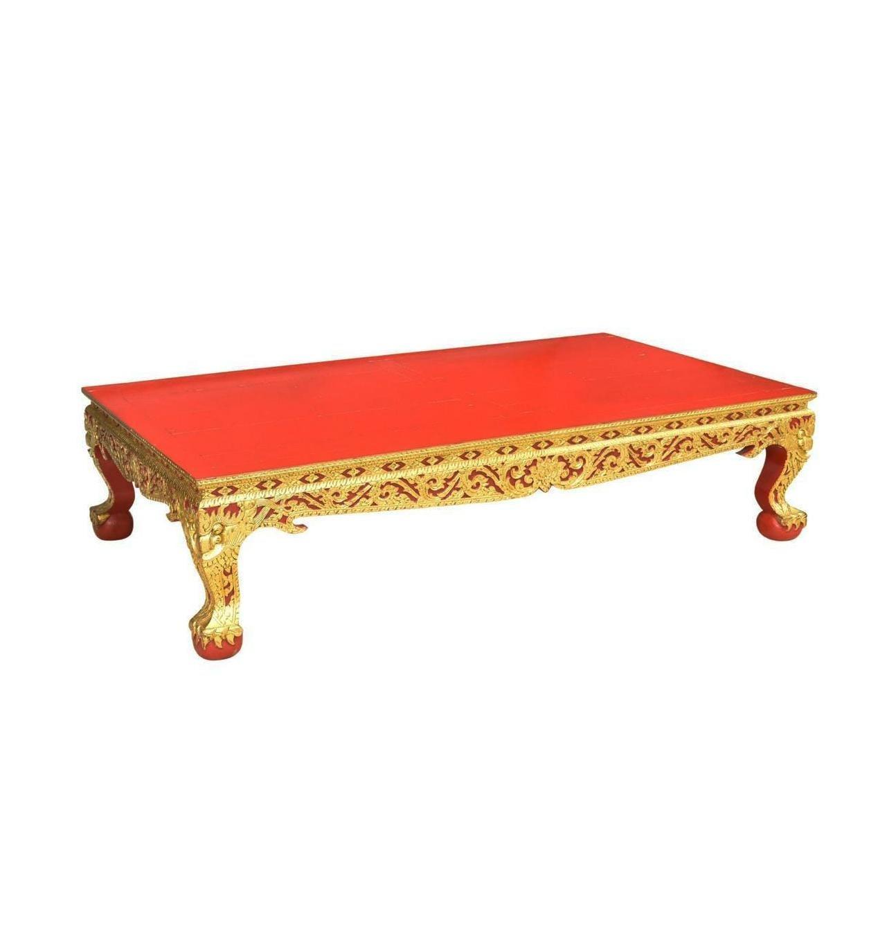 Tavolo del sud-est asiatico laccato rosso e dorato. Inizio e metà del XX secolo. Questo tavolo presenta un piano rettangolare, su grembiule e gambe intagliati e dorati, con motivi foliati a volute, su piedi a sfera, il retro non è dorato, perdita di