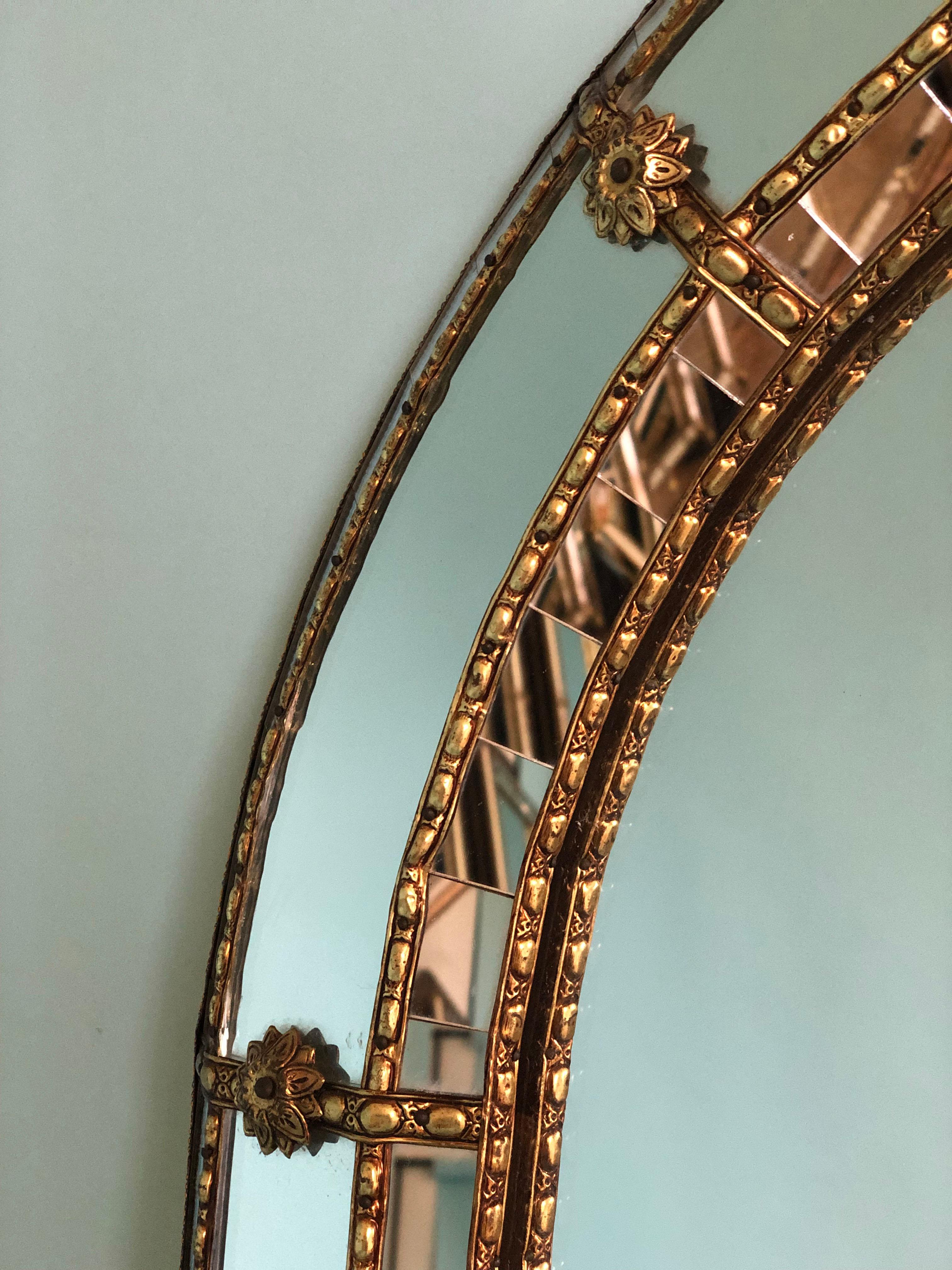Beautiful Spanish large mirror with a Venetian glass frame with a brass golden strip. The frame is made with small crystals both on the outside and inside, and larger ones in the center line. The brass strip holds the mirrors together.

Handmade