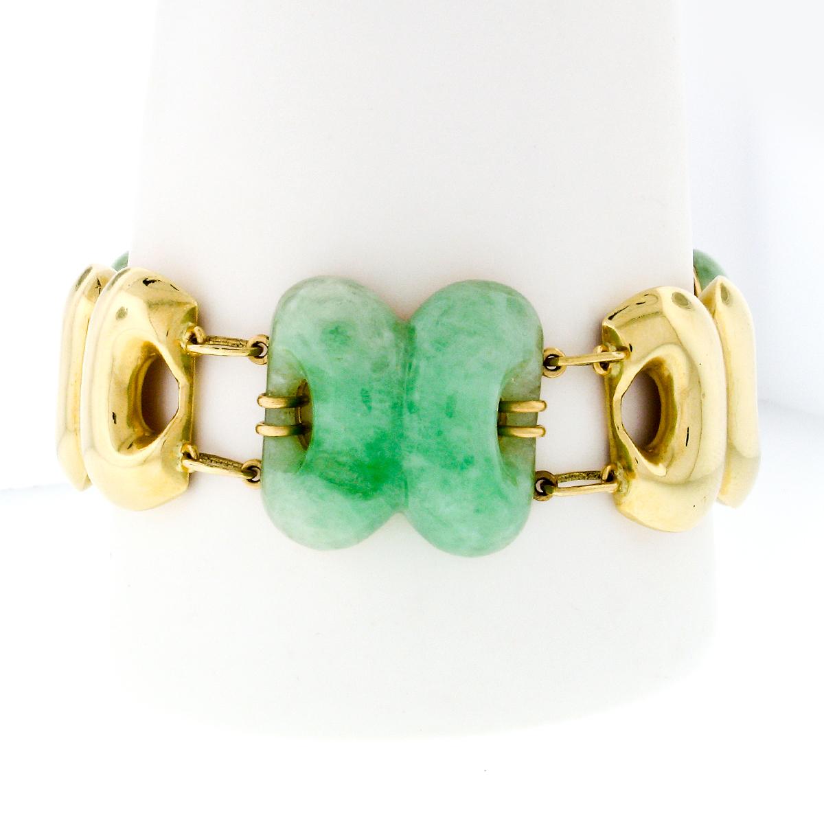 This bold vintage bracelet was crafted from solid 14k yellow gold and features alternating pierced jade and 14k yellow gold links. Both the jade stones and the gold links have the same dual ring design. Each of the jade stones is securely prong set