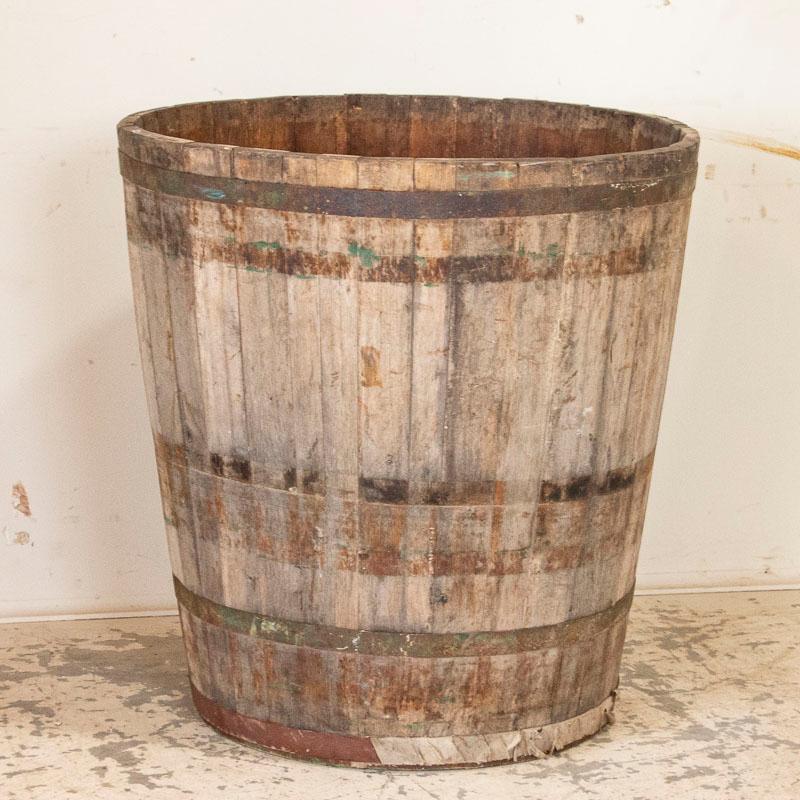 A fun vintage farm find, this large tub still maintains 3 of the metal bands that encircle it. If you look closely at the photos, you will see faint residual remains of green paint. A hole has been drilled in the lower section (easily viewed in the