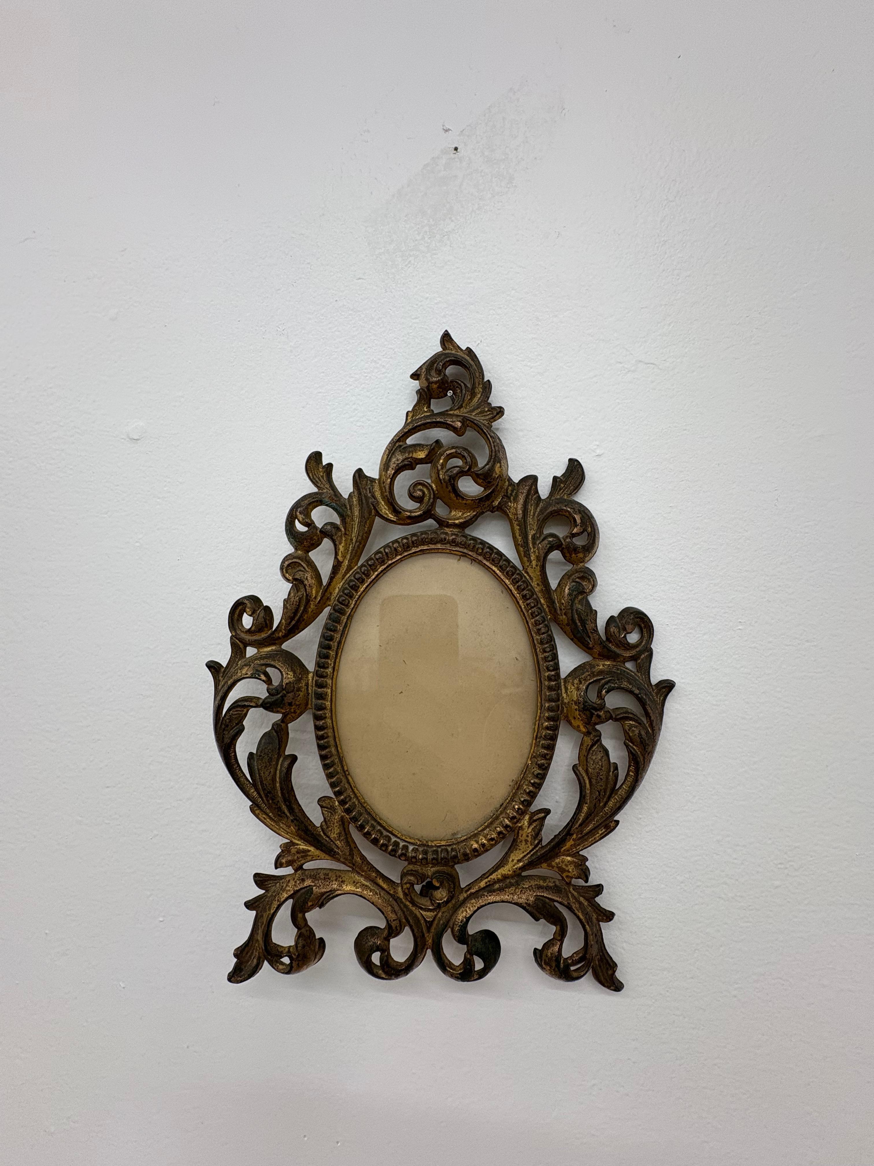Cattura la bellezza senza tempo dell'epoca vittoriana con questa cornice barocca dorata della fine del XIX secolo, un esempio straordinario di design Rococò Revival. Realizzato in solido metallo fuso con una calda finitura dorata, questo pezzo