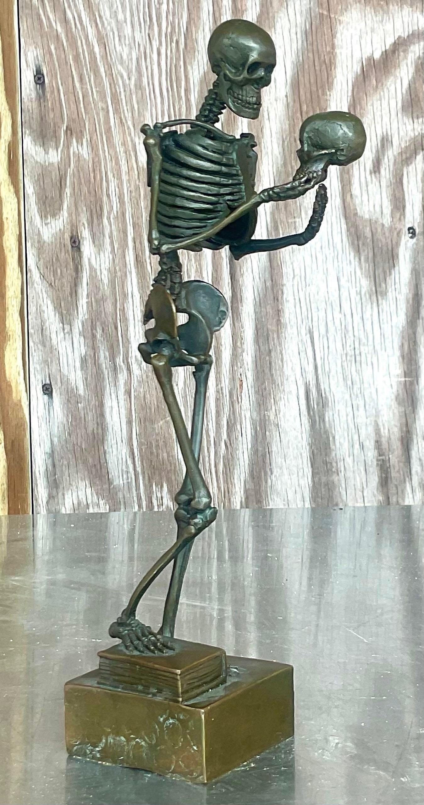 A fabulous vintage Boho signed bronze sculpture. A chic skeleton holding a skull. Sure to add a little zing to any space. Acquired from a Palm Beach estate.