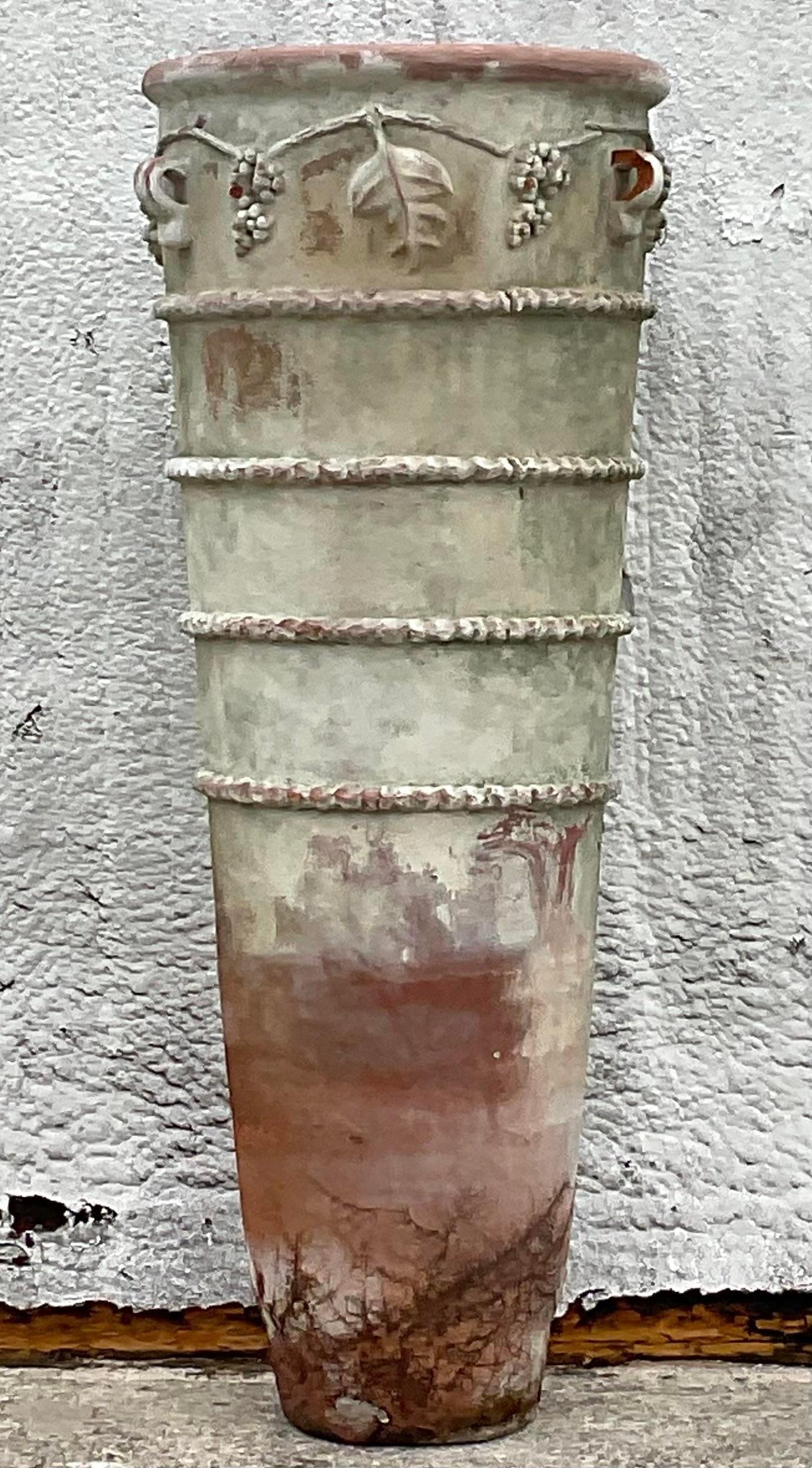 A fabulous vintage Boho planter. A chic tall terra Cotta planter with a fabulous patinated finish. Monumental in size and drama. Acquired from a Palm Beach estate.