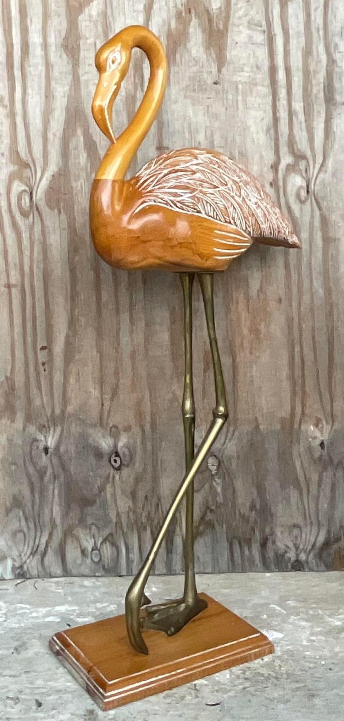 A stunning vintage Coastal monumental flamingo. A chic hand carved bird with a light wash finish. Stands in sold brass legs. Acquired from a Palm Beach estate.