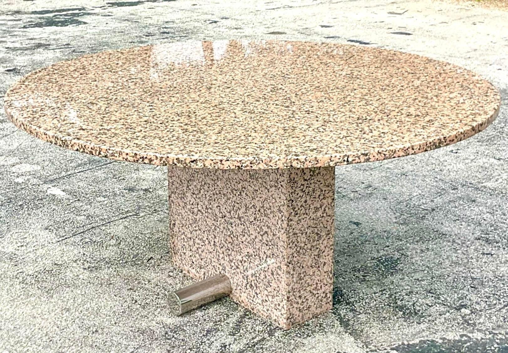 A fabulous vintage Contemporary dining table. A chic granite table with a chrome rod at the base. A strong graphic design in a pale peach and grey tones. Acquired from a Palm Beach estate.