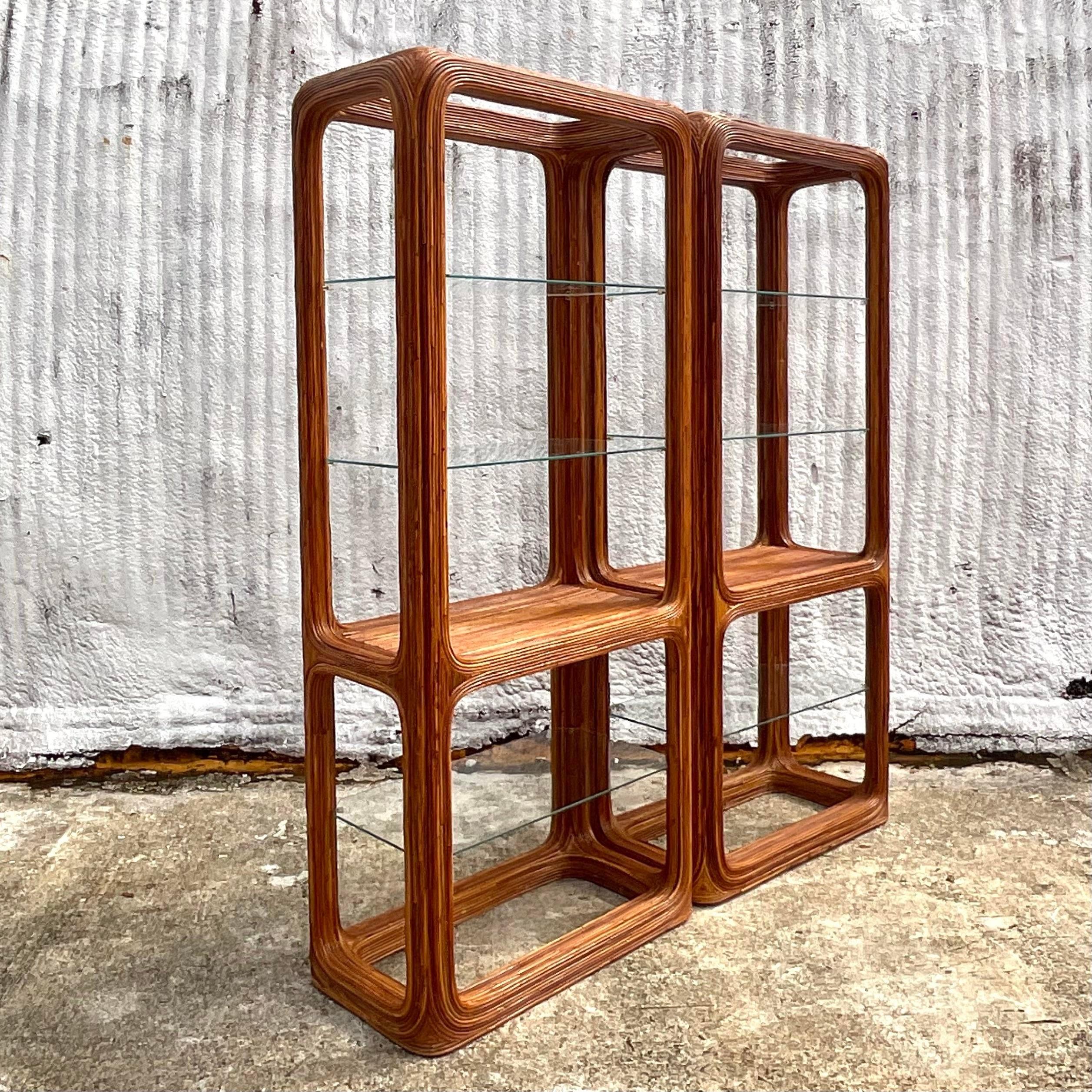 A vintage Coastal Rattan and glass etagere. A beautiful pencil reed construction with inset glass shelves. A beautiful waterfall corner shape. Acquired from a Palm Beach estate.
