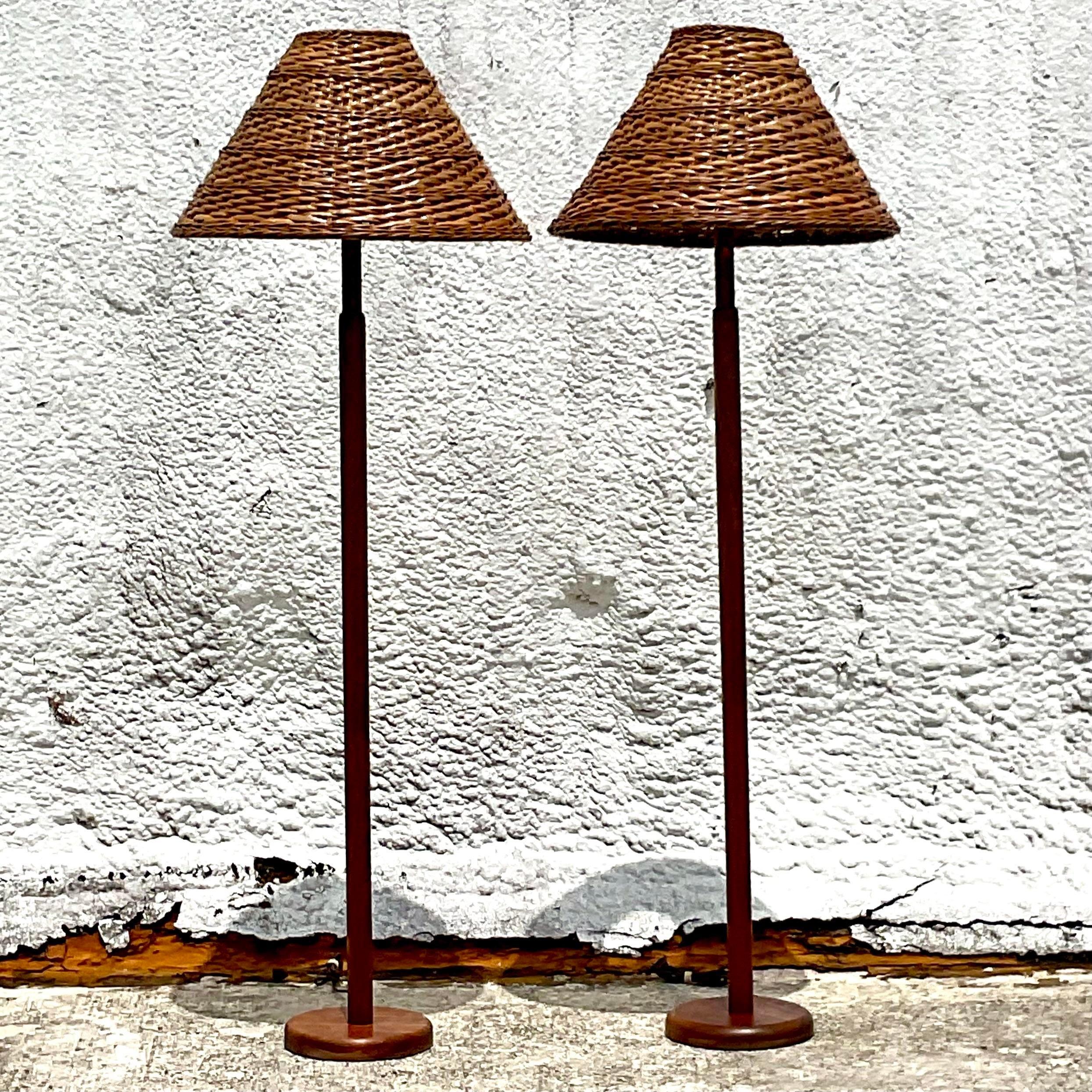 A fabulous pair of vintage Coastal floor lamps. Gorgeous MCM teak lamps in a simple and clean design. A great pair of woven rattan shades. Acquired from a Palm Beach estate.