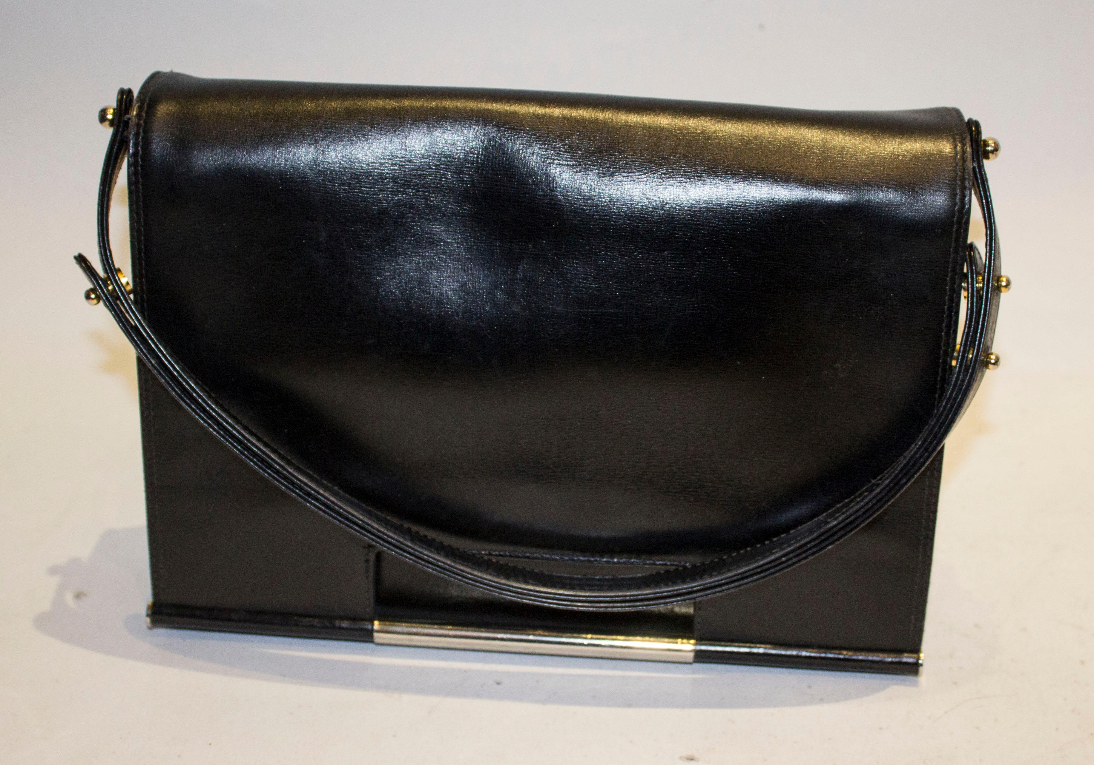 A chic vintage black leather bag by Launer. The bag has a flap over front with popper fastening and pouch pocket at the back. Internally there is a zip pocket in the lid ( like Chanel) and two compartments , one with a small pouch pocket.  The