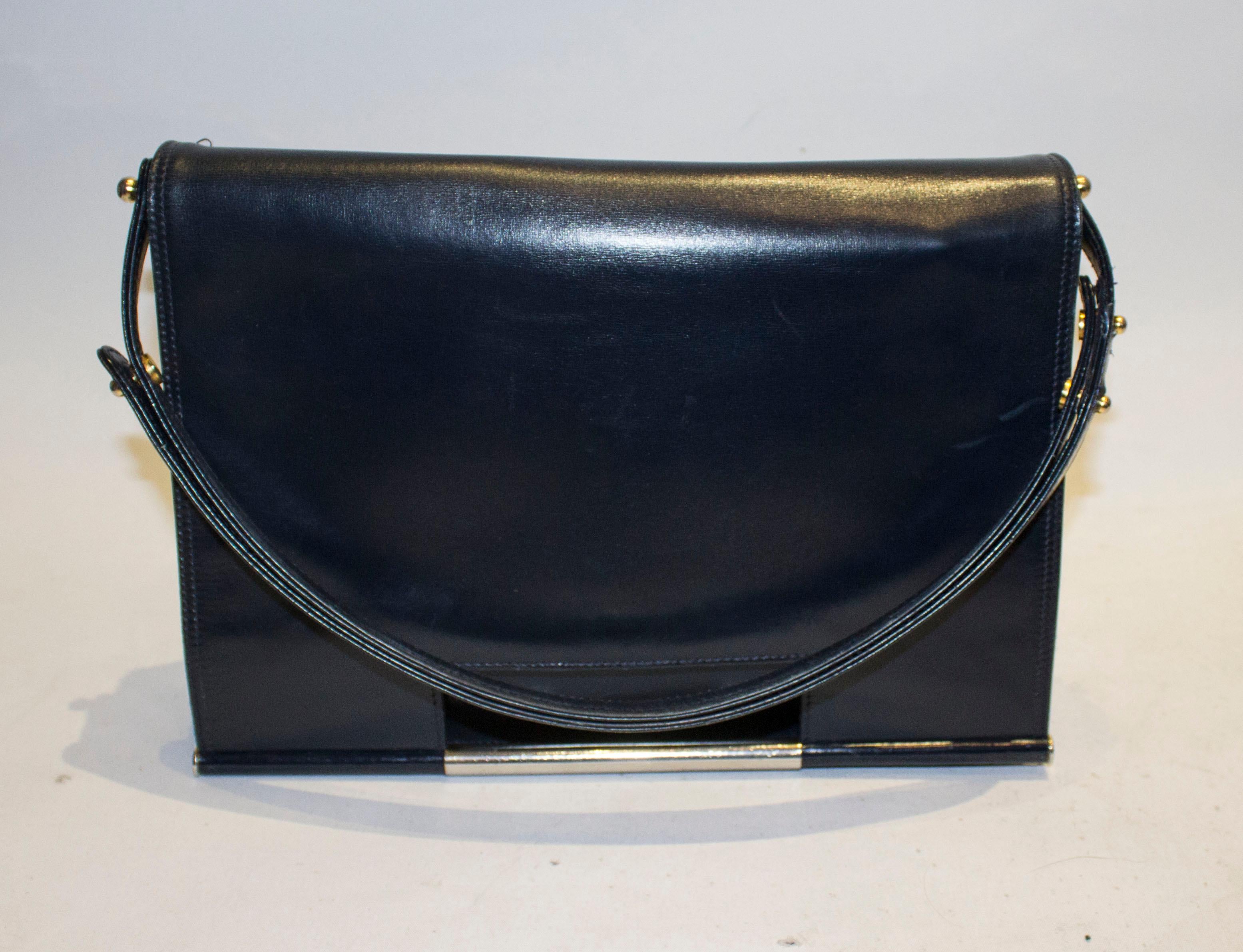 A chic vintage bag by Launer ( Bag maker to the Queen). In a deep navy blue , the bag has a flapover front with popper fastening, and back pouch pocket. Inside there is a zip compartment in the lid ( similar to Chanel) and two compartments , one