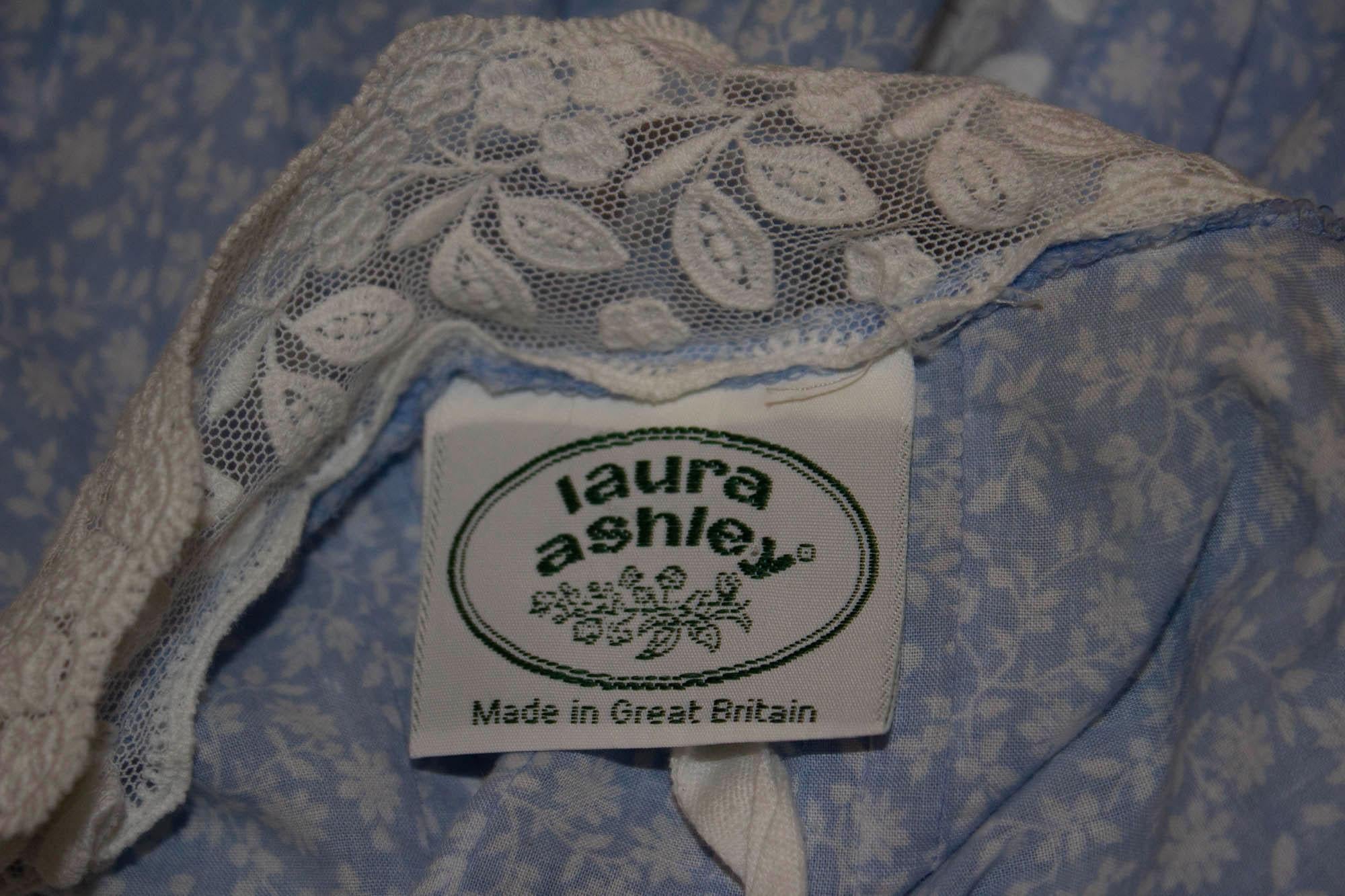 A pretty vintage Laura Ashley dress and bolero. They are both in a blue and white print. The dres s has a central back zip, folds on the front and thin straps. The bolero jacket has stitch detail on the front and sleaves with a lace trim on the cuff
