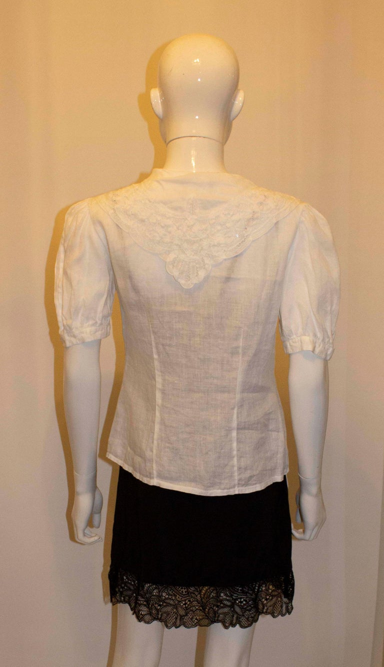 A pretty vintage linen blouse by  Laura Ashley. The blouse has a lace shawl collar, vertical pleats on the front, and short sleaves with gathering. 
Size 10 Measurements: Bust 36'', length 23''