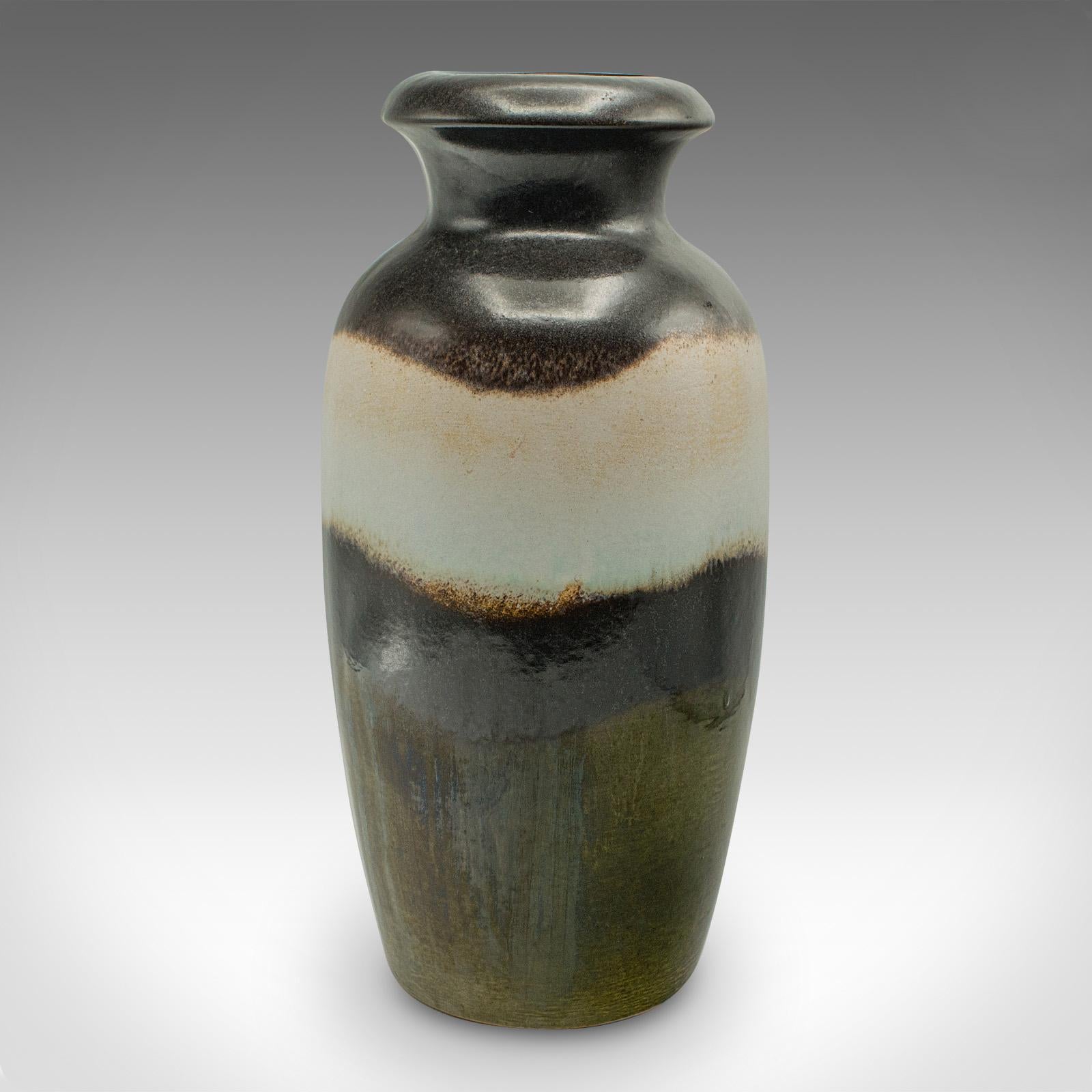 
Il s'agit d'un vase à fleurs en lave vintage. Urne balustre en céramique d'art d'Allemagne de l'Ouest, datant du milieu du 20e siècle, vers 1960.

Décoration attrayante du milieu du siècle, avec des couleurs et des finitions distinctives
Présente