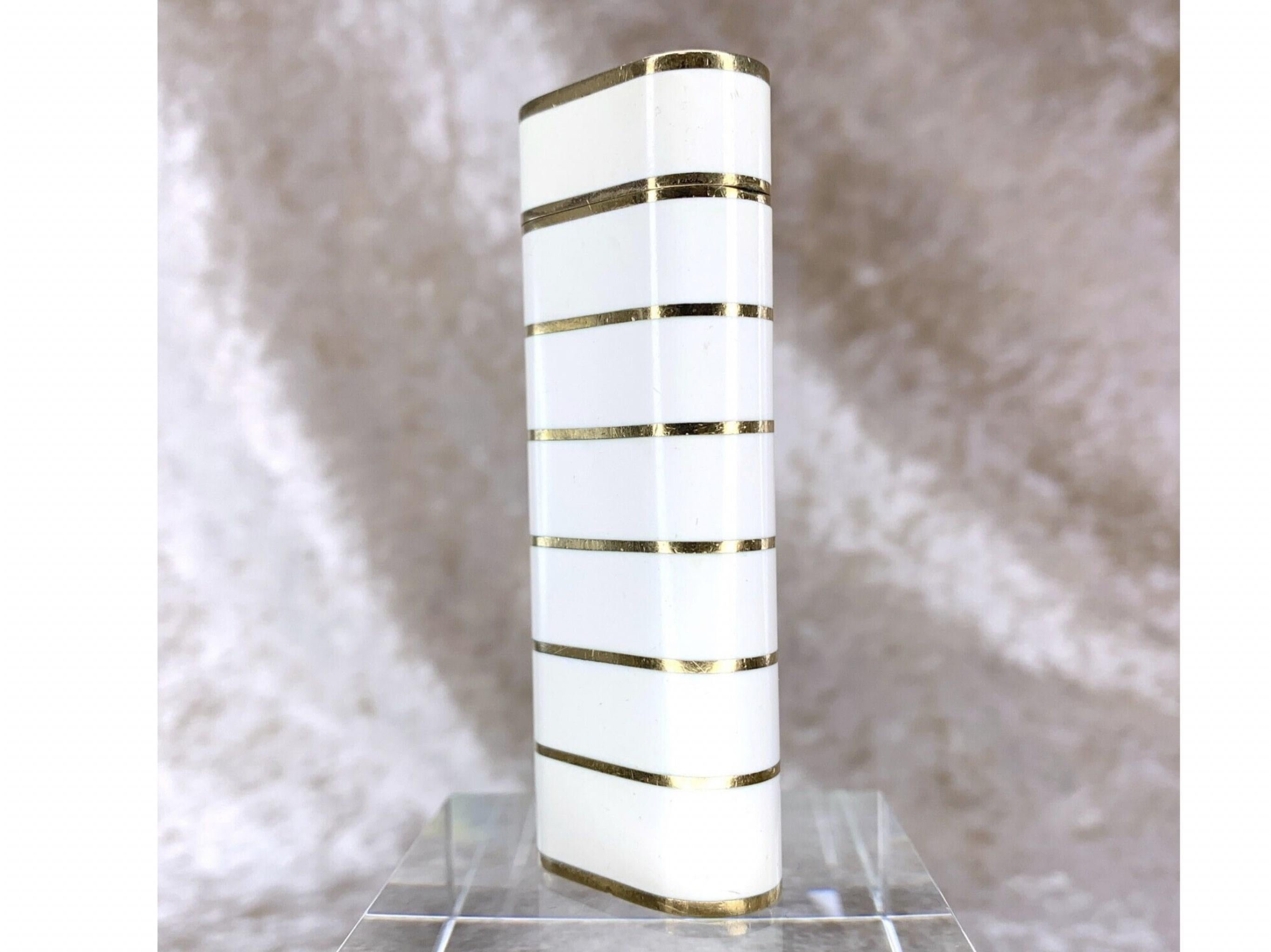 Beautiful and Very Rare Vintage Cartier Lighter in White Lacquer 
Gold Plated Horizontal Gold Stripes 
Le Must De Cartier 
Circa 2000
In mint working condition
The lighter sparks, ignites and flames 
Comes with Original Cartier Case 
Elegant and