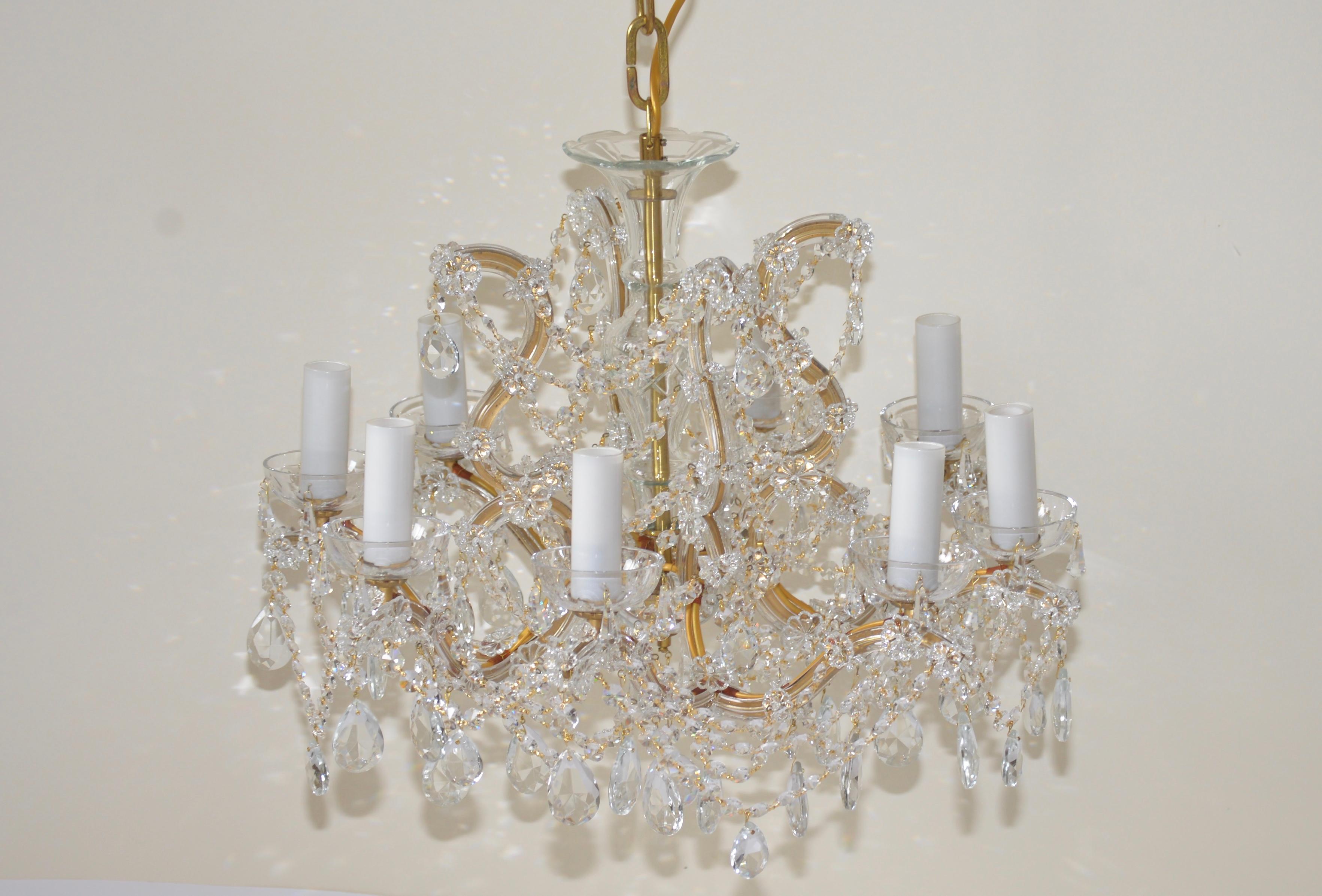 A beautiful handcut crystal Bohemian chandelier. This item has eight profiled glass arms with cut crystal octagons and pear drop shaped lead crystals in small and large sizes throughout this beautiful chandelier. There are eight candle bulb lights