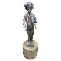 Vieille statue figurative en plomb d'une casserole musicale avec flûtes sur un piédestal en pierre