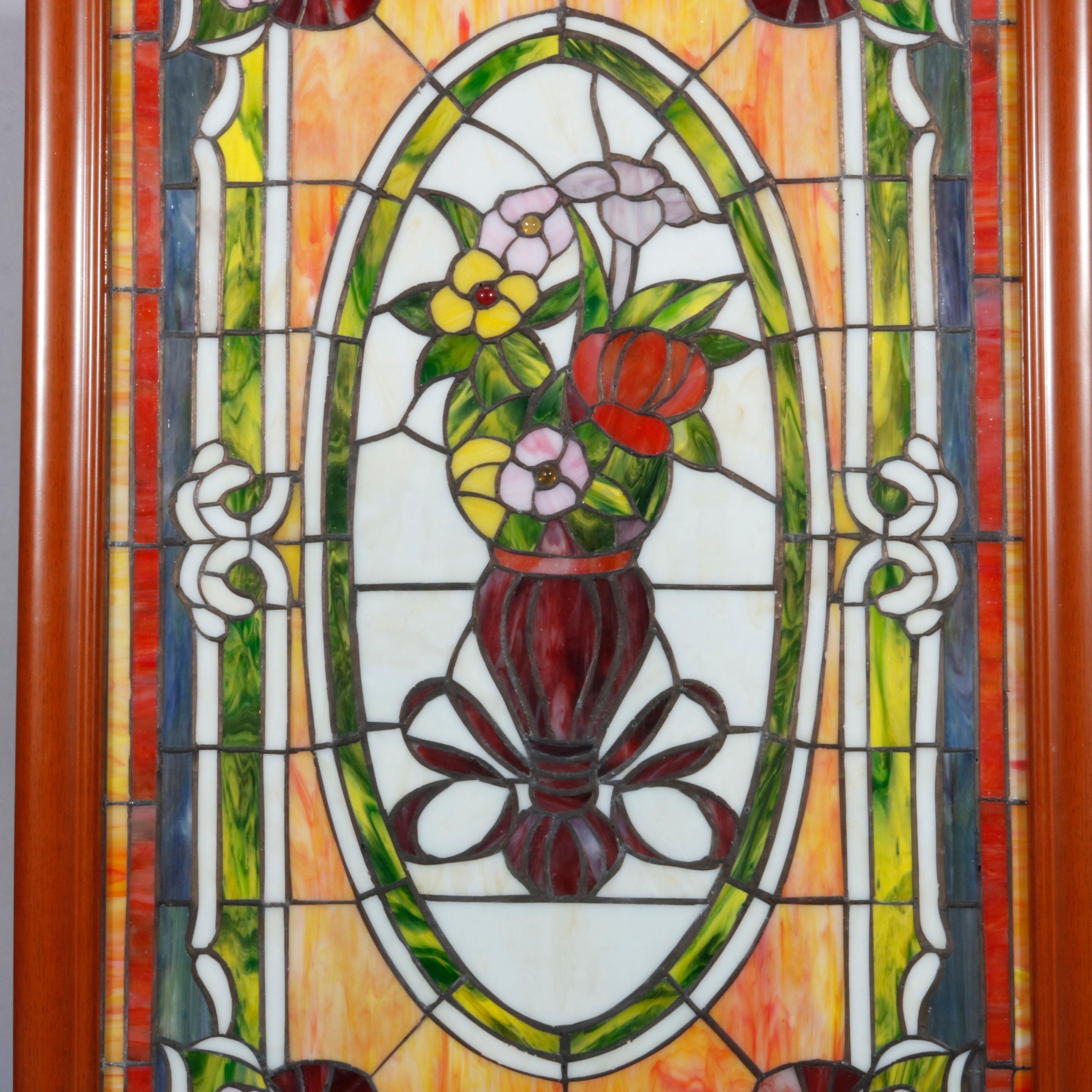 A vintage leaded stained and slag glass window offers central medallion with floral bouquet, seated in wood frame, 20th century

Measures: 36.75