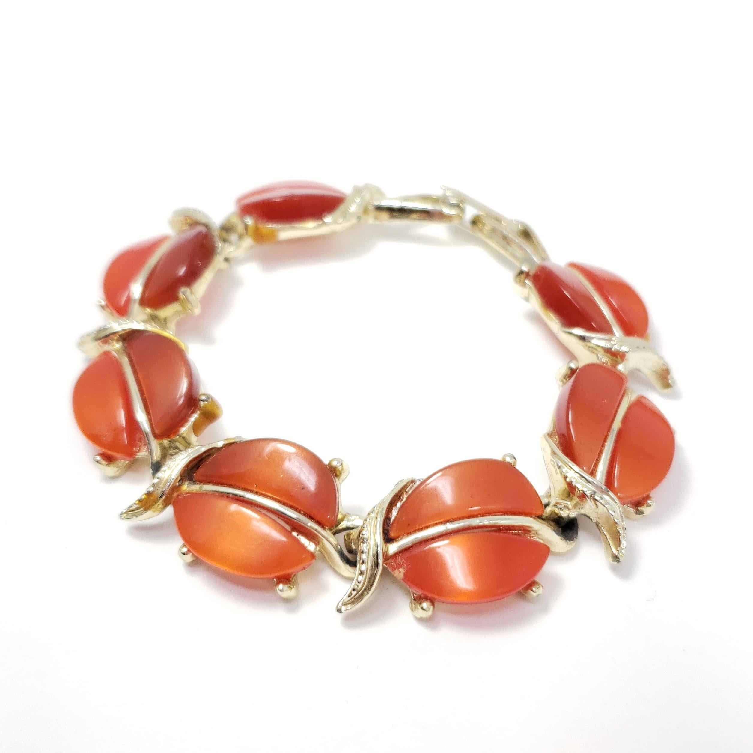 Un bracelet rétro extravagant avec des motifs de feuilles de couleur ambre, sertis dans des maillons en or.

Plaqué or. Fermeture à rabat.