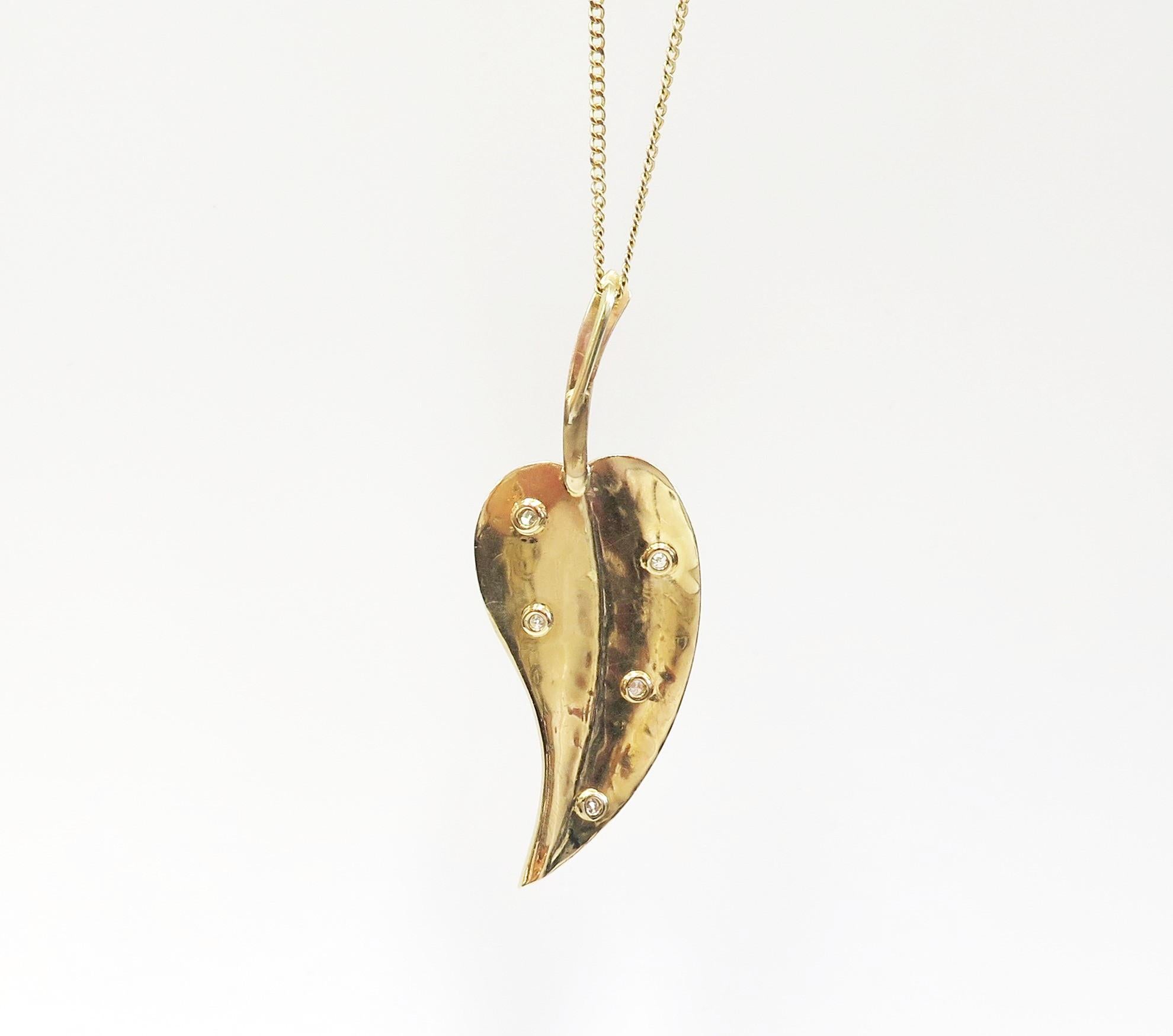 This is a graceful vintage leaf pendant with a matt finish and 5 Diamonds burnished into starburst etched settings. It hangs on a 22 inch chain from a loop that is hidden behind the stem of the leaf.

Length of pendant: 2 3/8