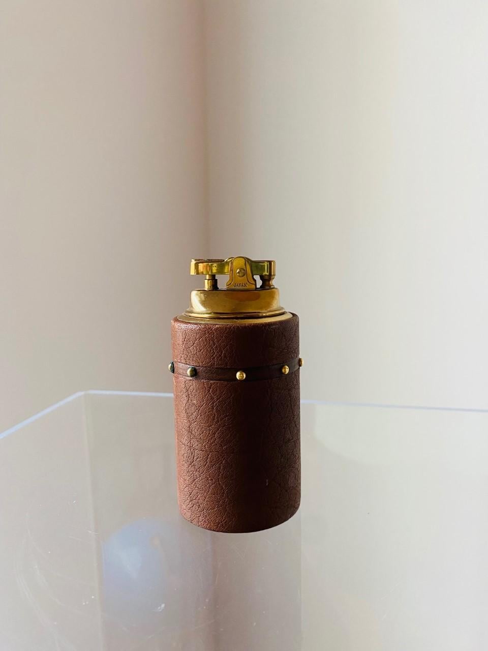 Beautiful and glamorous lighter. This piece has midcentury glamour and style all over it. The sizeable piece is enveloped in a brown leather with stud brass details and a felted base. This piece is from Japan and the craftmanship is incredible. The