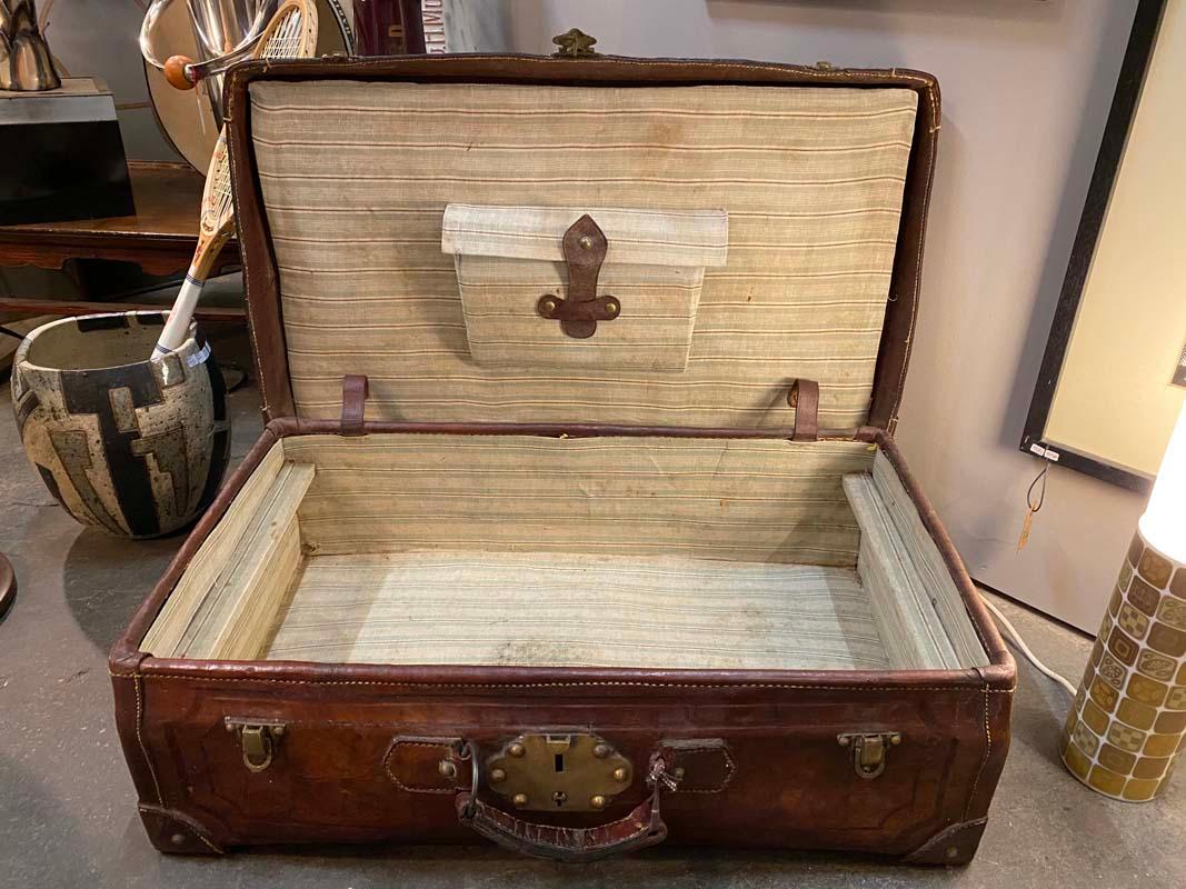 Vintage leather travel case with brass. This piece of luggage is handmade and has strong signs of use. From the inside it is lined with striped fabric. Rare decorative accessory, excellent for vintage car friends and fans.
