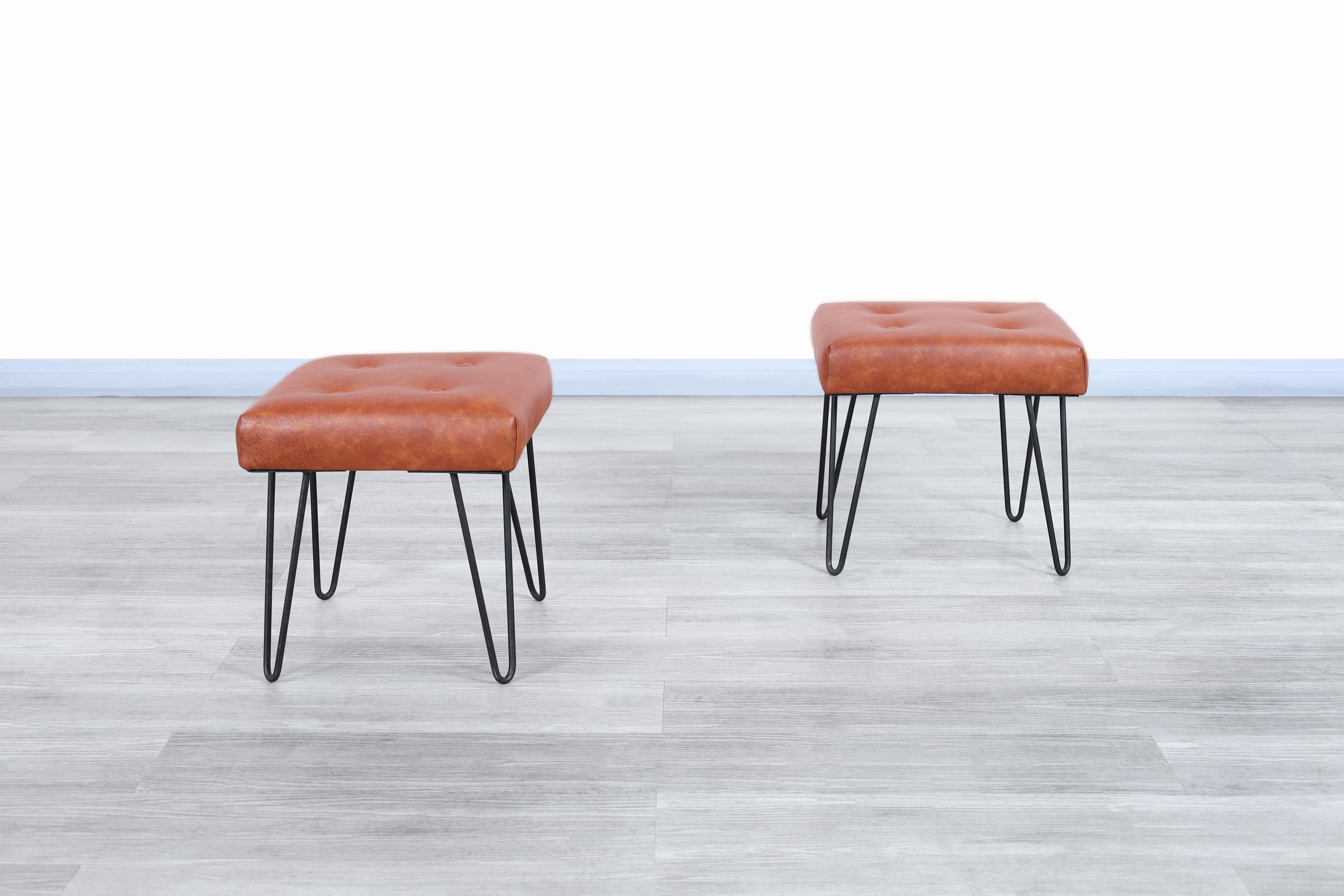 Fabulous vintage leather and iron stools designed and manufactured in the United States, circa 1950s. These stools have an elegant structure that prioritizes beauty and space for the user. Each stool has leather-upholstered cushions, on which