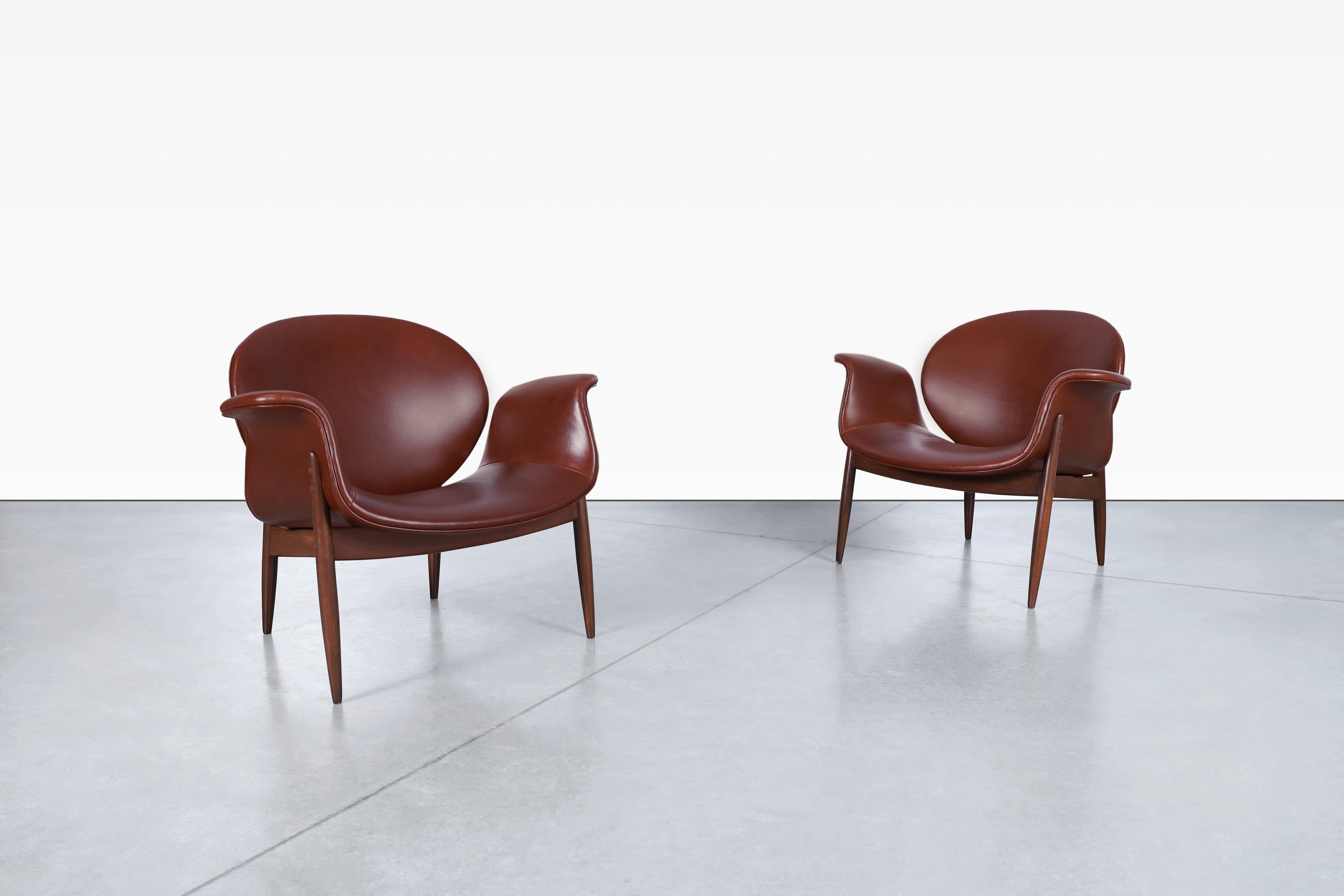 Amazing vintage leather and walnut “Swan” lounge chairs designed by Arthur Umanoff for Madison Furniture in the United States, circa 1960s. These chairs are a true testament to the art of furniture making, featuring the finest high-quality Italian