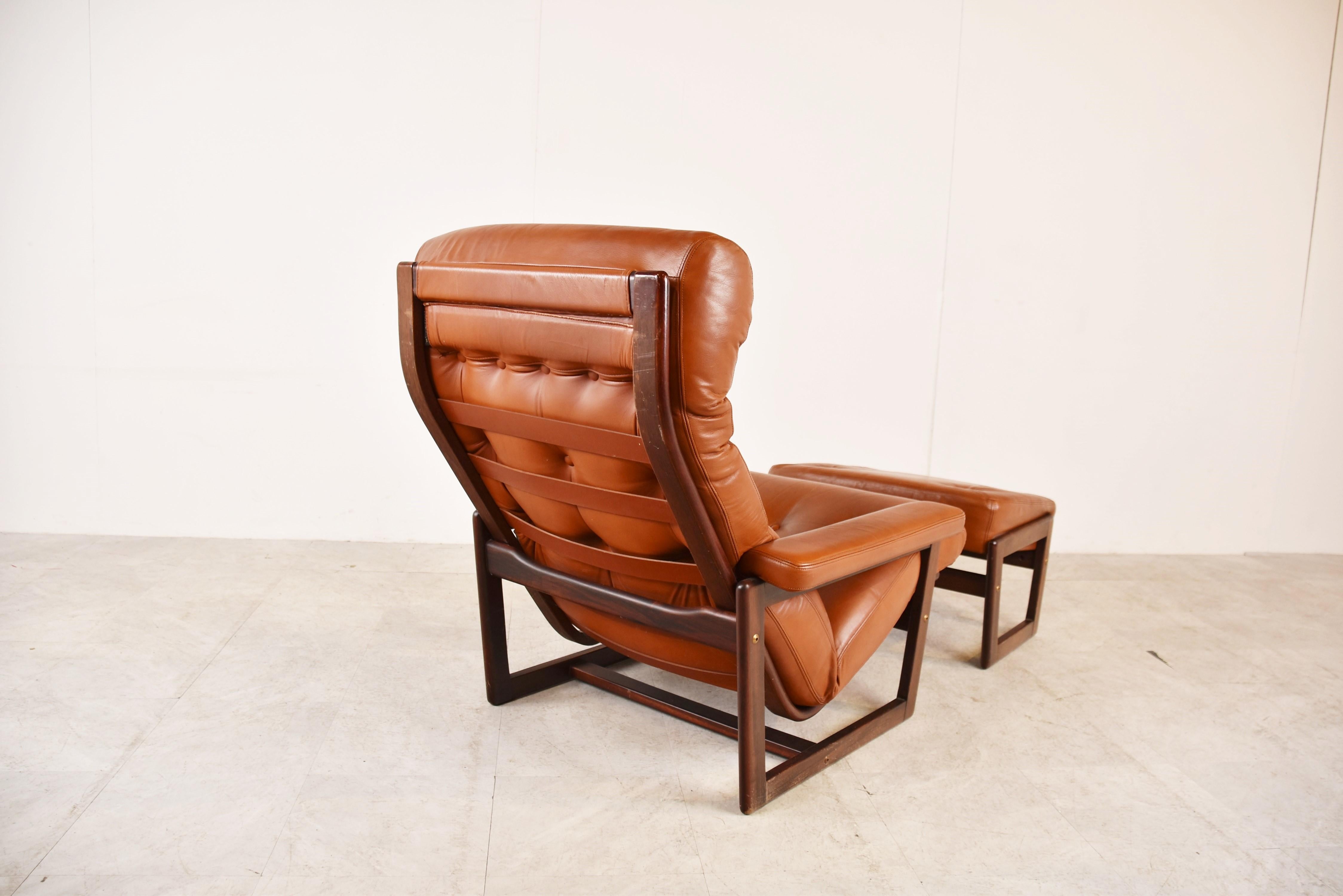 Mid-Century Modern leather armchair with hocker.

Very comfortable chair with thick leather cushions and a stained oak frame.

1960s - Germany

Good condition

Dimensions:
Height: 90cm/35.43